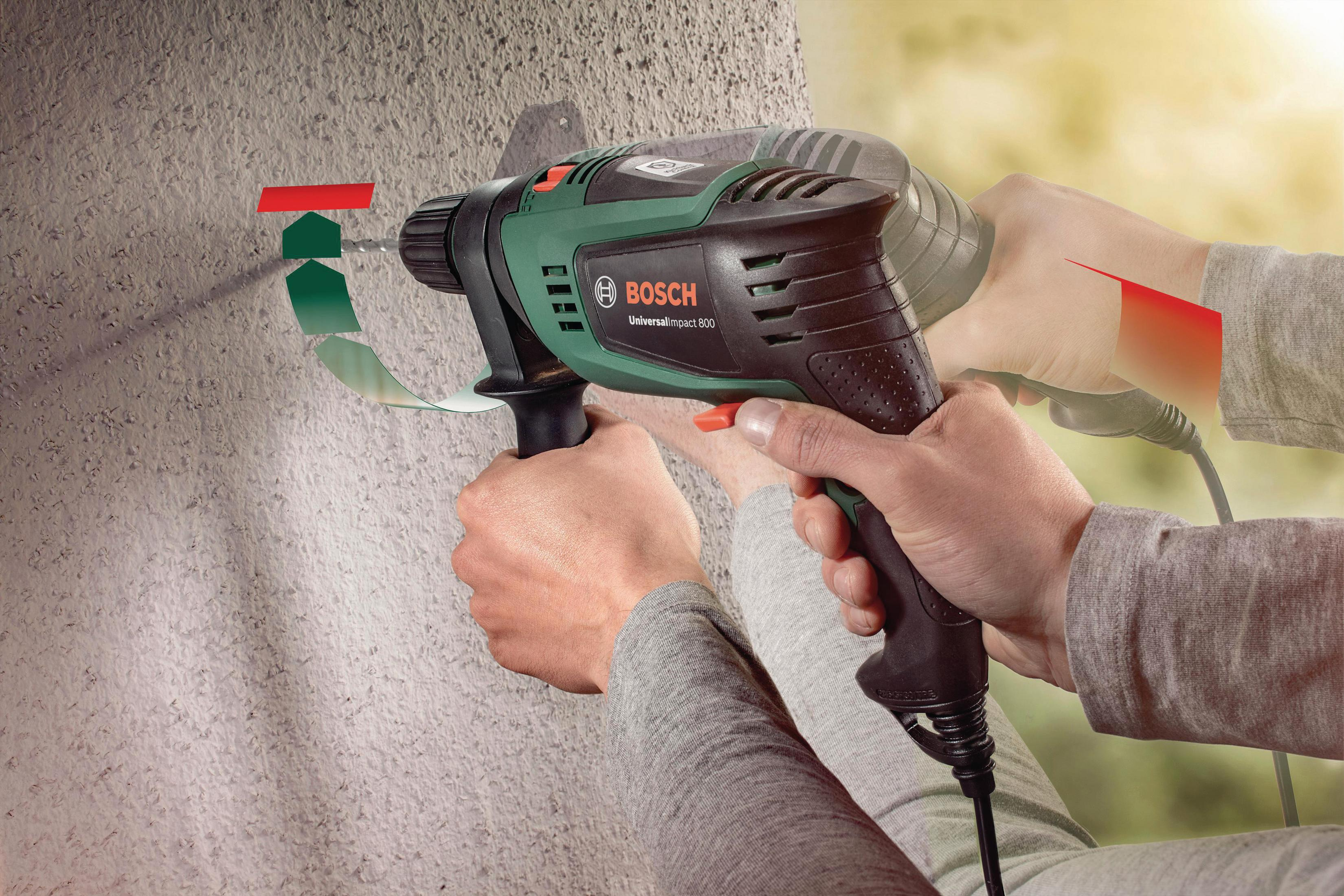 Duvar üzerinde Bosch matkap kullanan bir kişi, yeşil ve kırmızı işaretlerle.