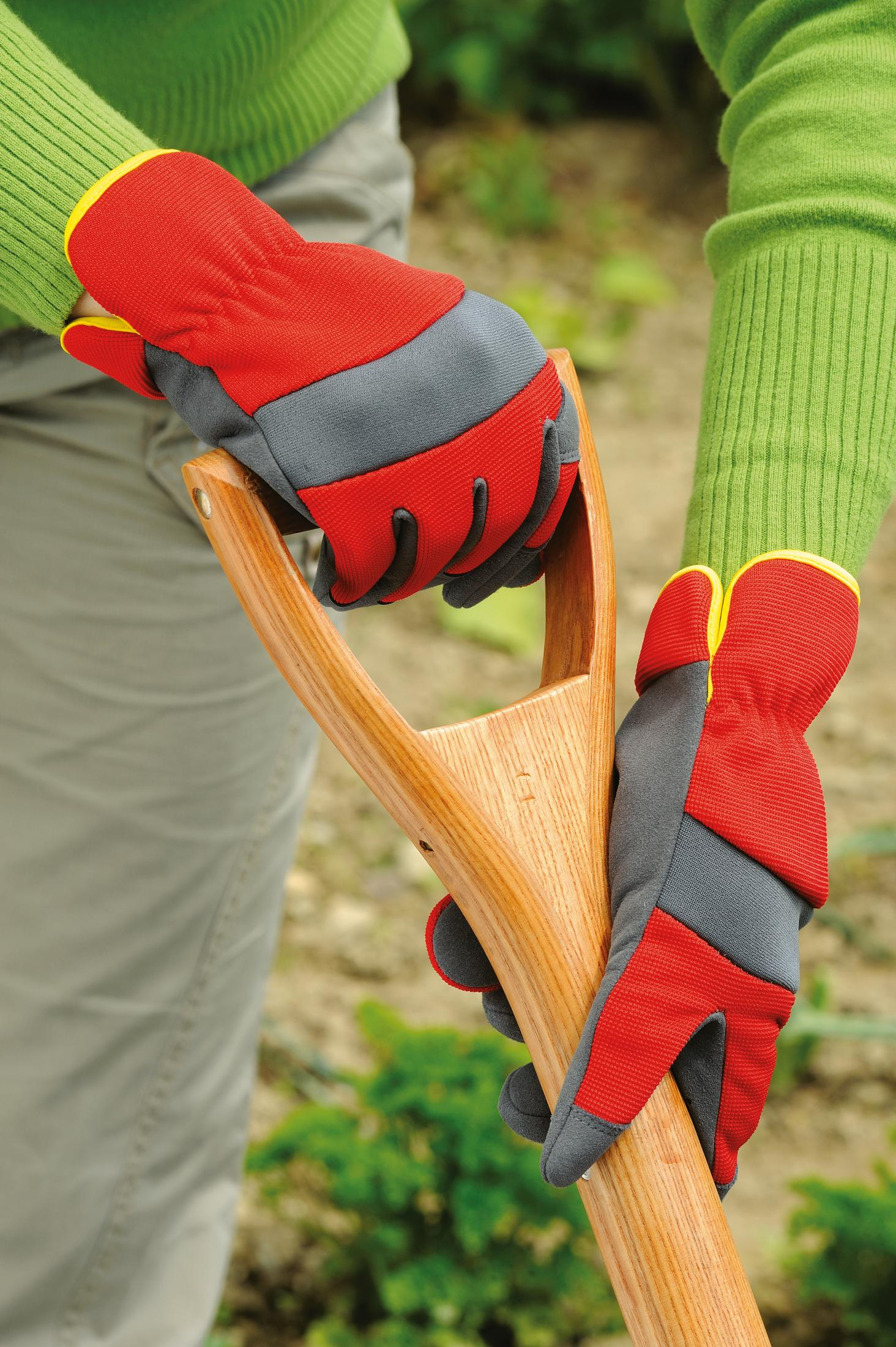 Hände mit roten, grauen und gelben Handschuhen halten ein Gartengerät.