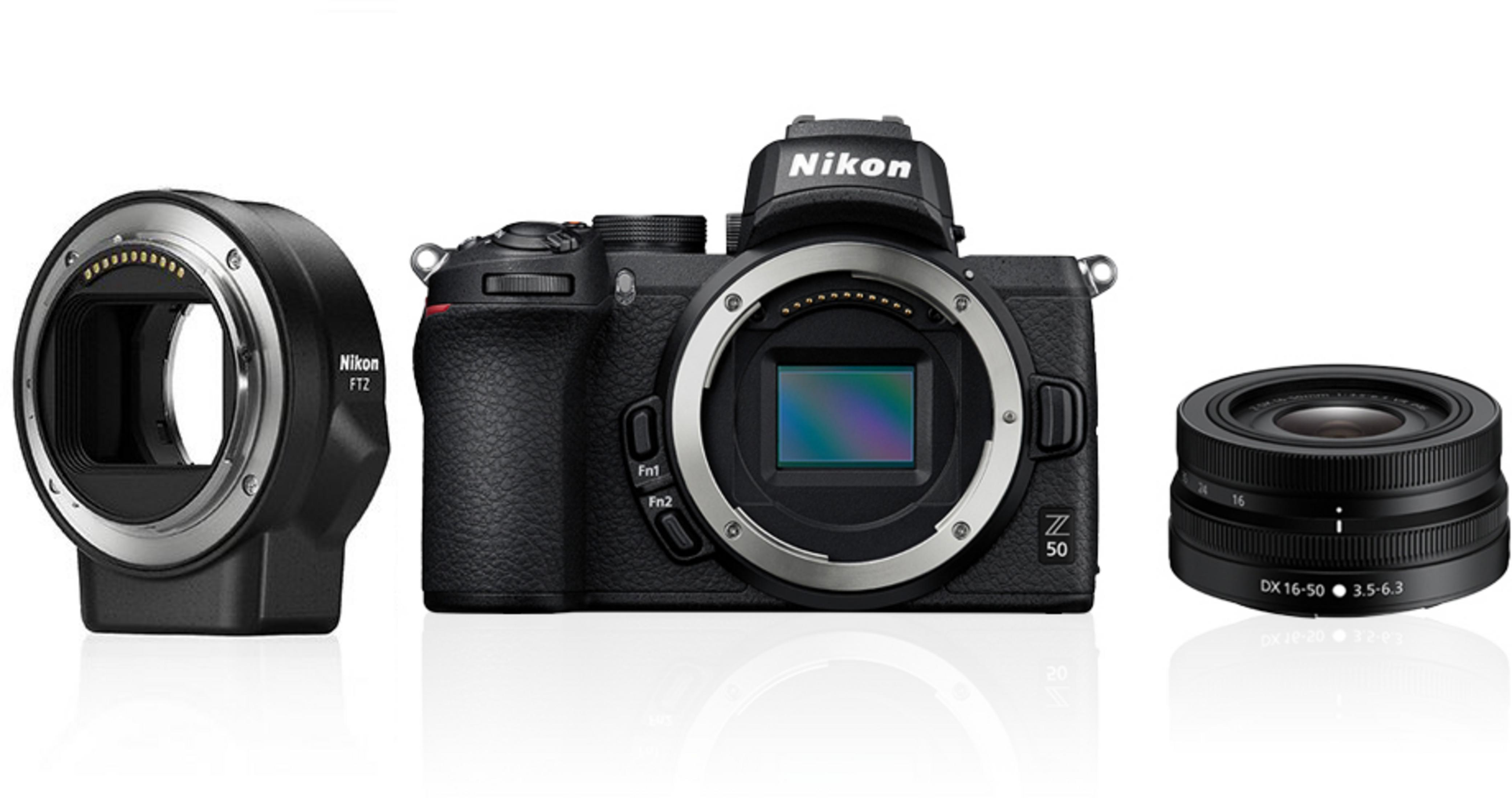 Eine Nikon Z 50 Kamera mit Objektiv, ein Objektiv und ein Objektivanschluss auf weißer Oberfläche.