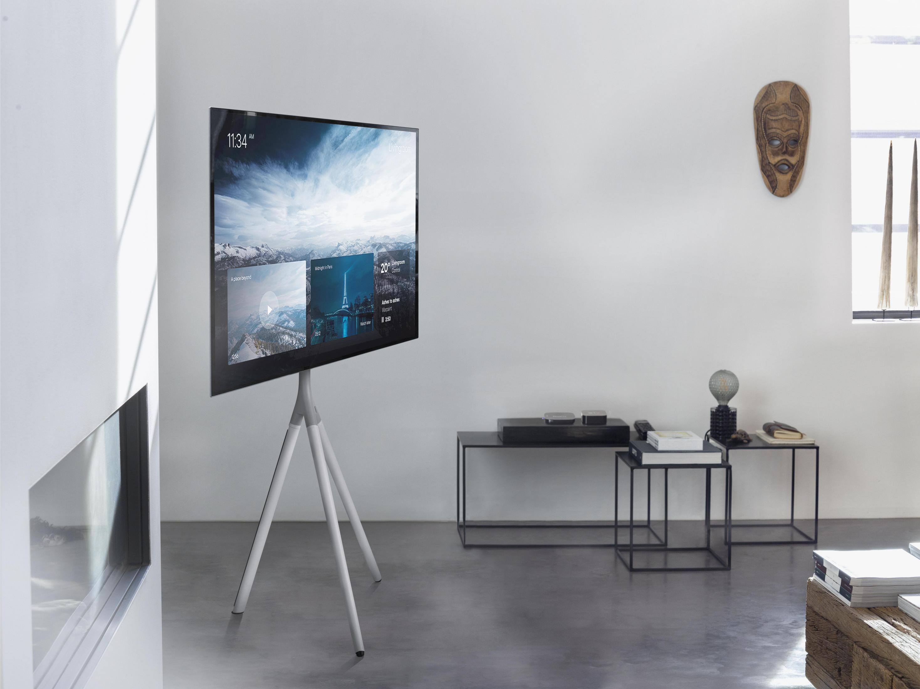 Een moderne woonkamer met een tv op een standaard, een open haard en minimalistische decoratie.
