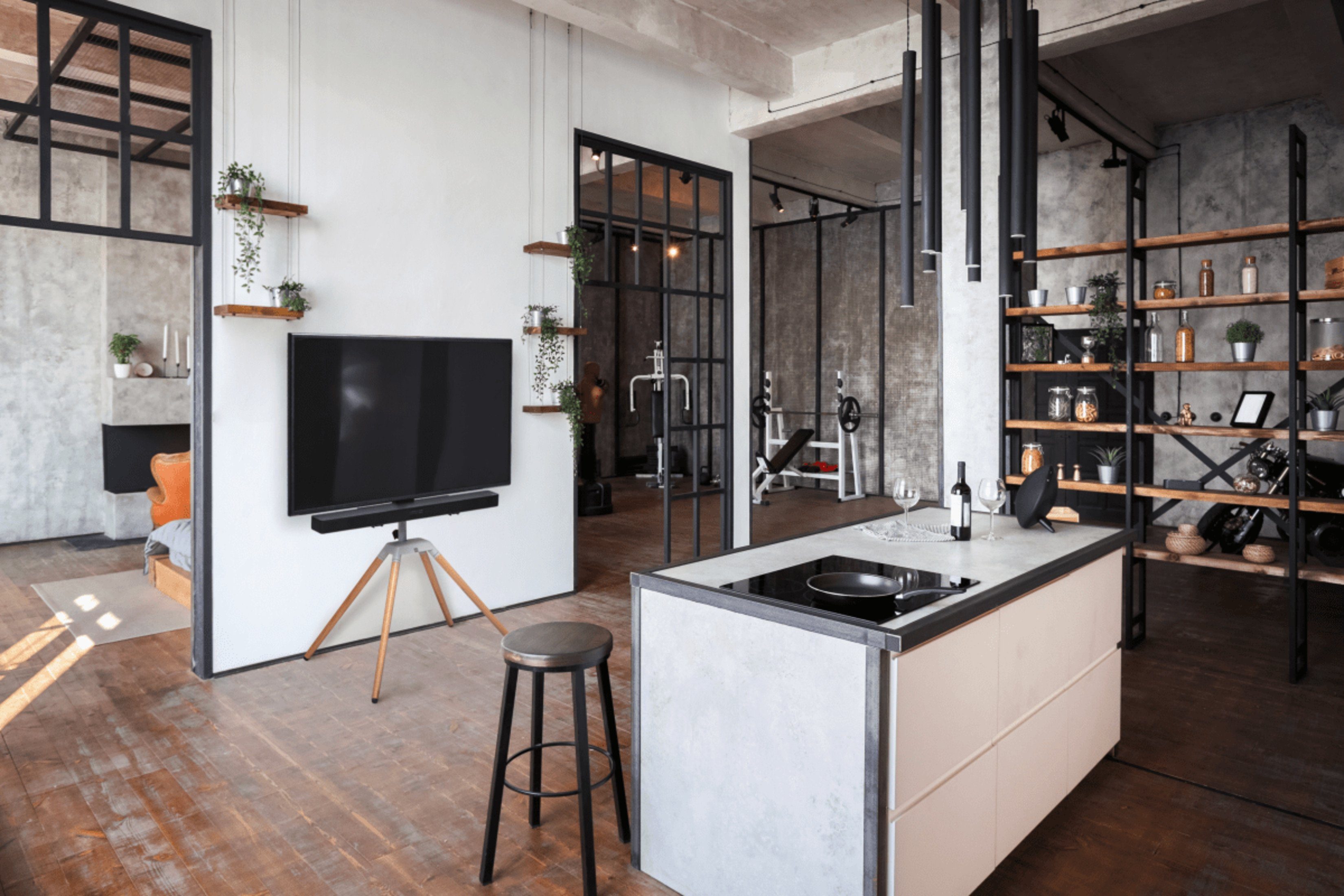 Moderne open woonruimte met keuken, tv en zicht op een andere kamer.