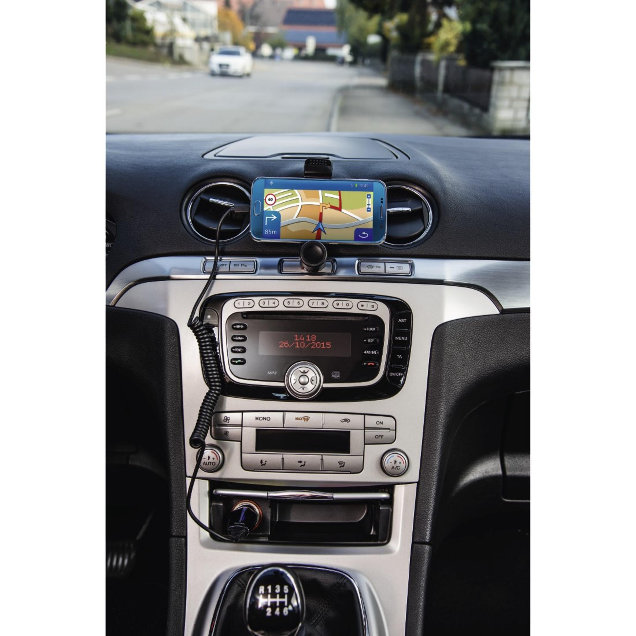 Wnętrze samochodu z telefonem z nawigacją, deską rozdzielczą i kierownicą. Widoczna droga.