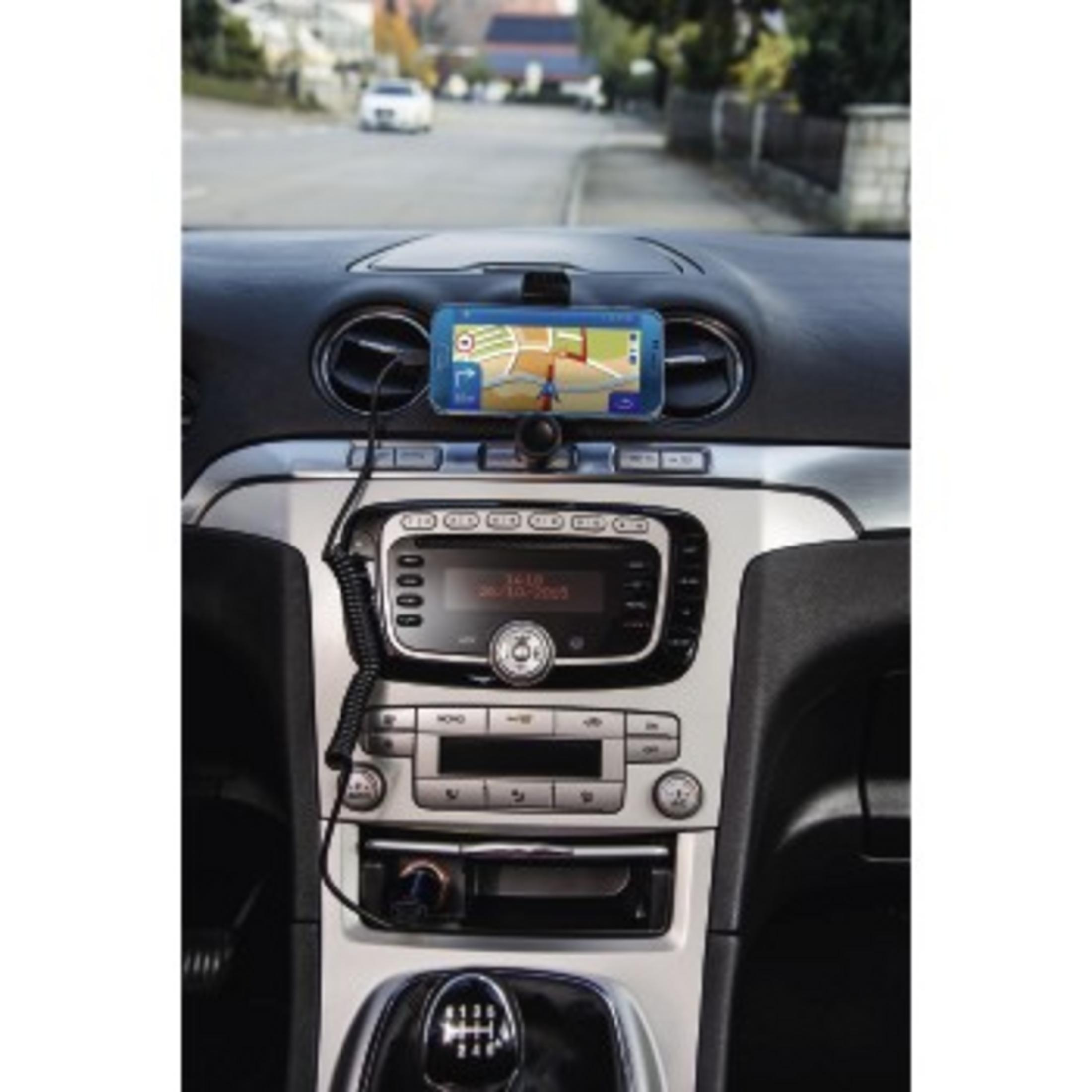 Wnętrze samochodu z uchwytem na telefon trzymającym telefon. Telefon wyświetla nawigację. Widok deski rozdzielczej.