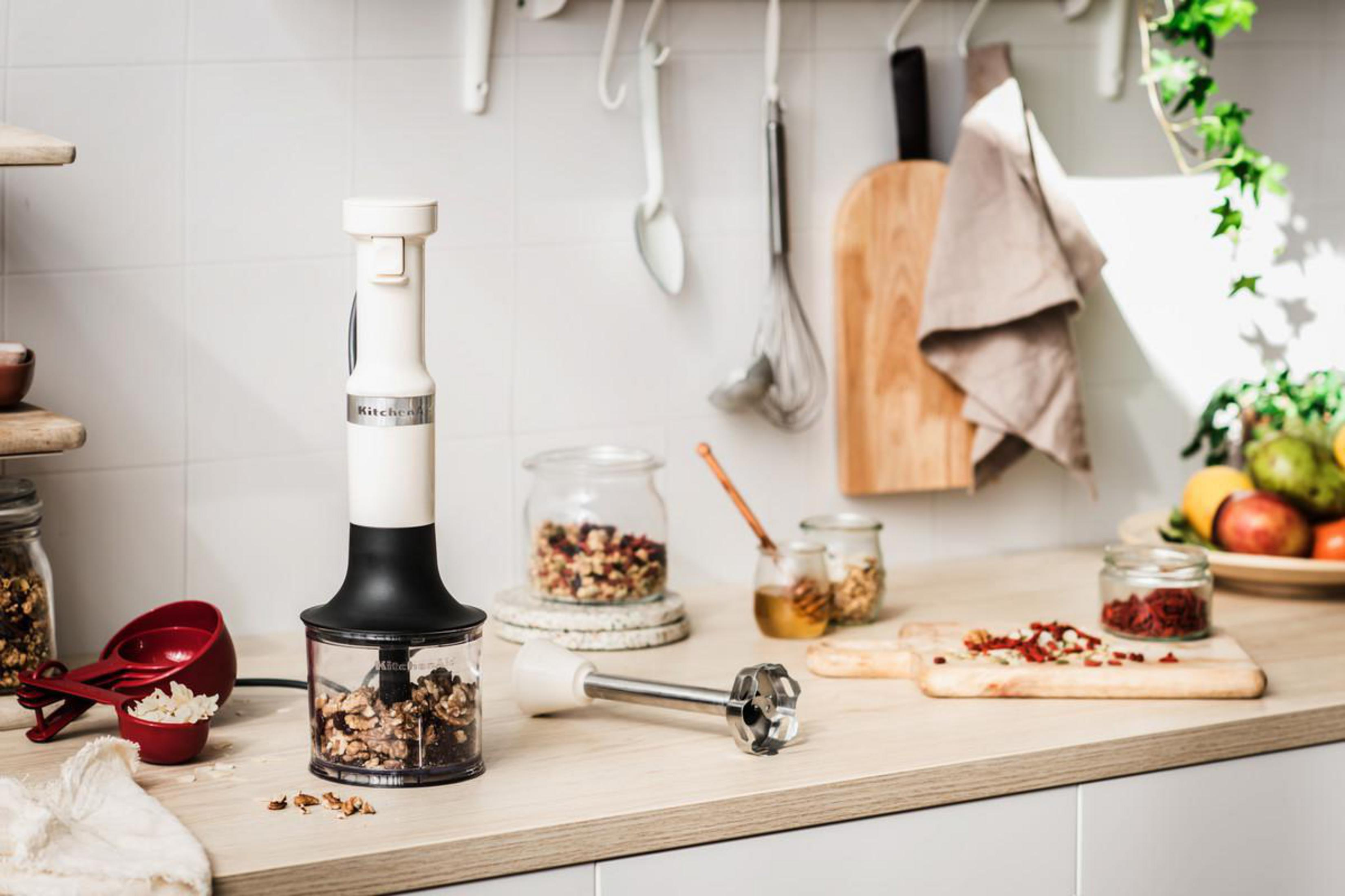 Scena kuchenna z białym i czarnym blenderem, składnikami i przyborami kuchennymi.