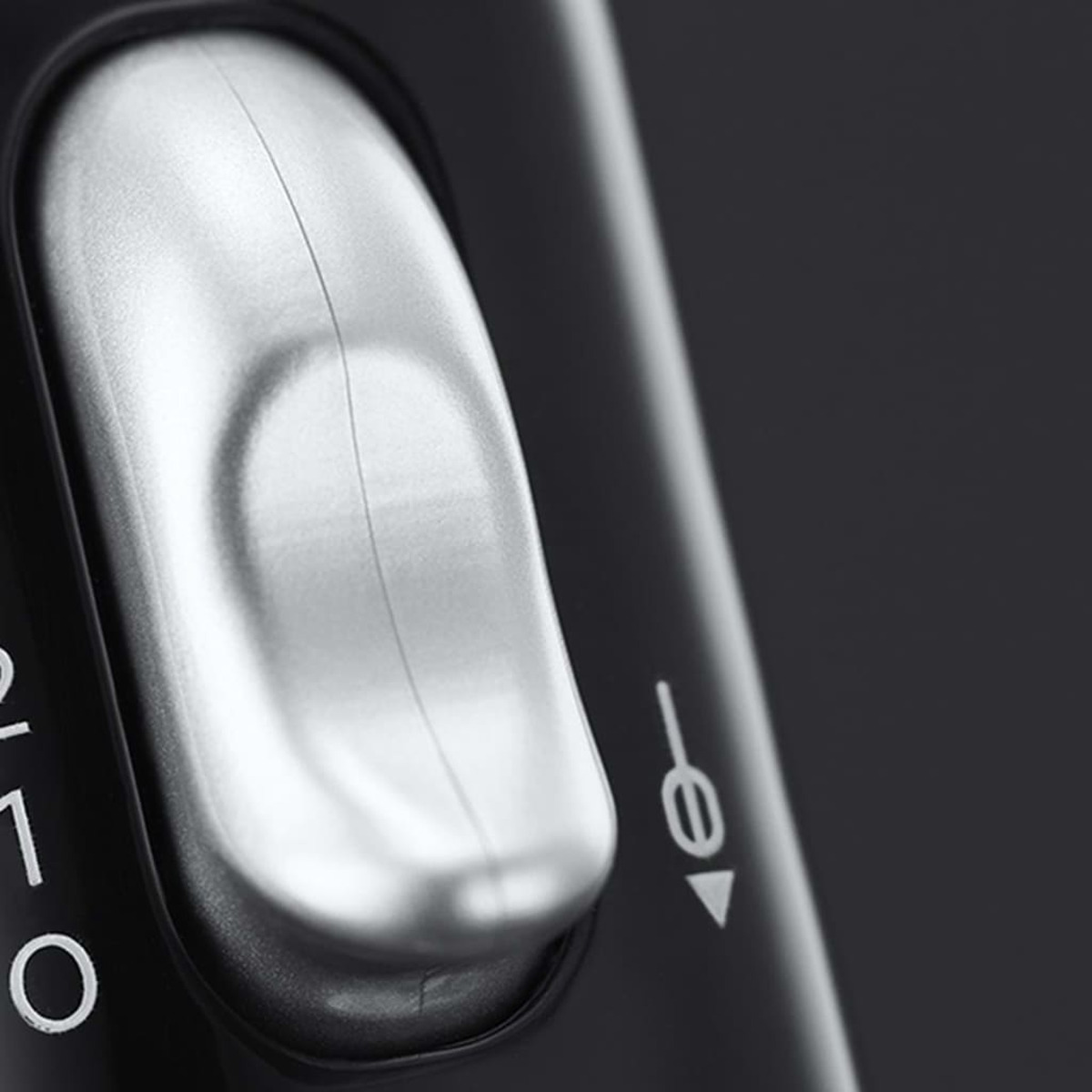 Zbliżenie czarnego pokrętła na czarnym urządzeniu.