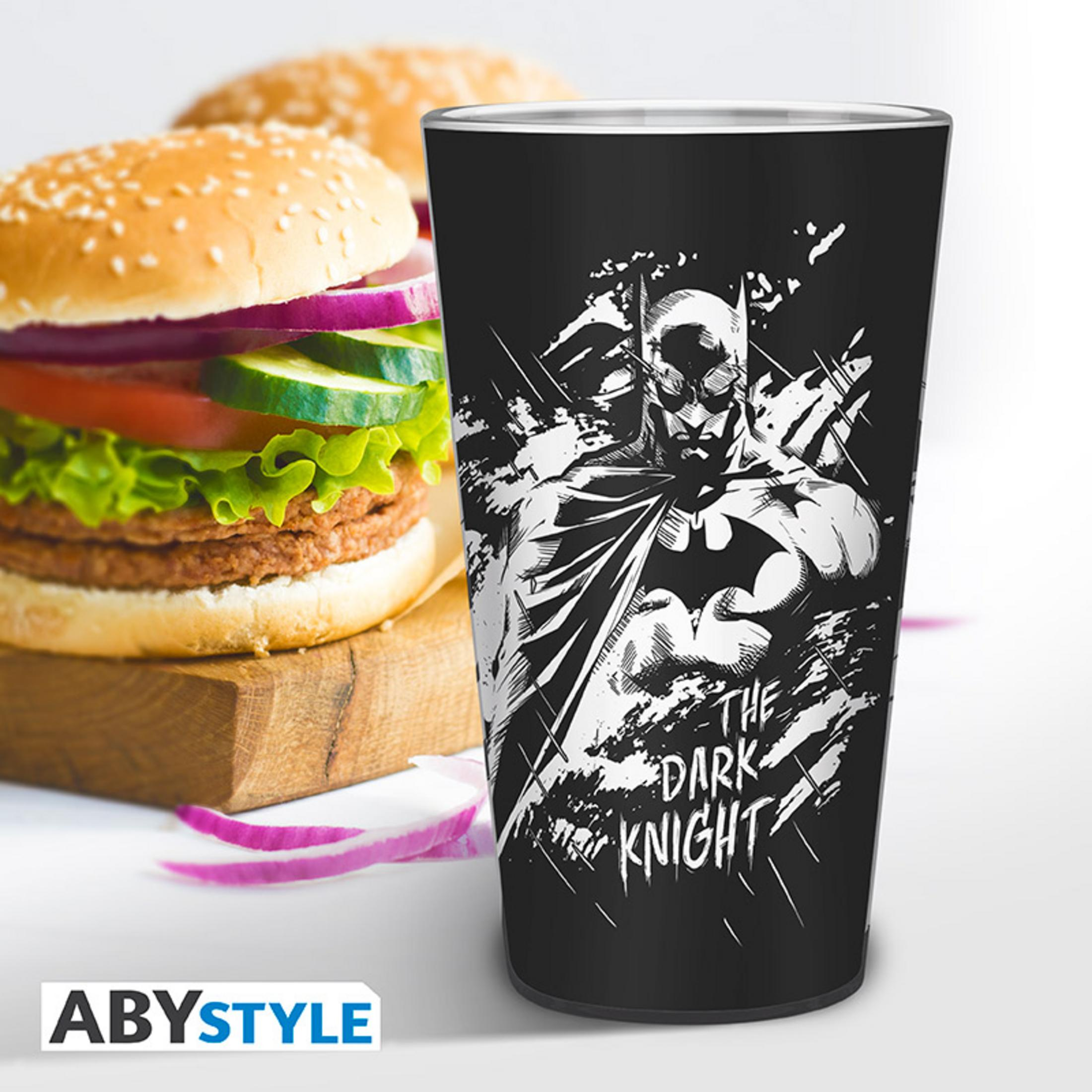 Batman-Glas mit Burger und Zutaten, Holzbrett, weißer Hintergrund.