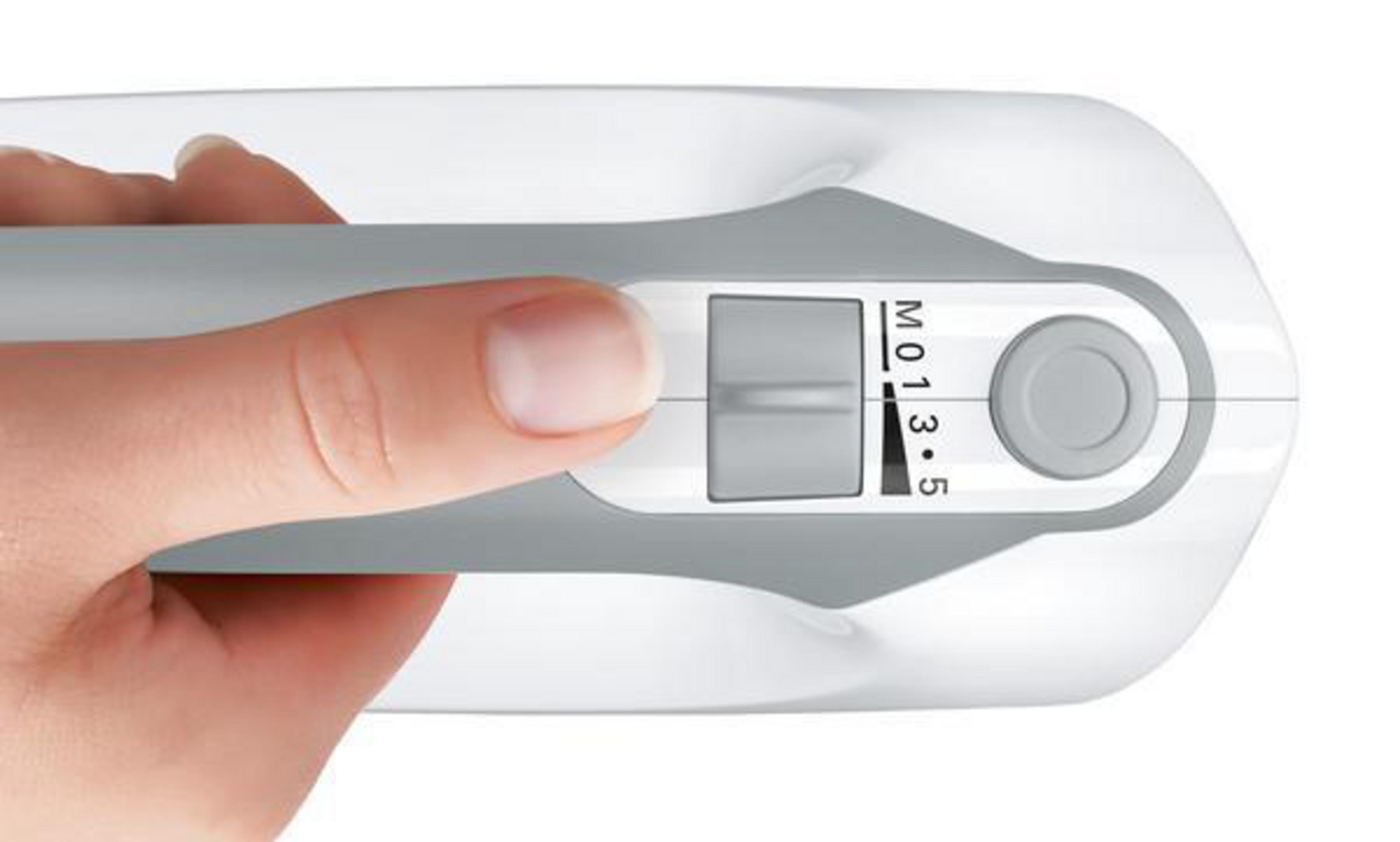 Ręka regulująca biało-szary przełącznik na białym urządzeniu, prawdopodobnie sprzęcie kuchennym.