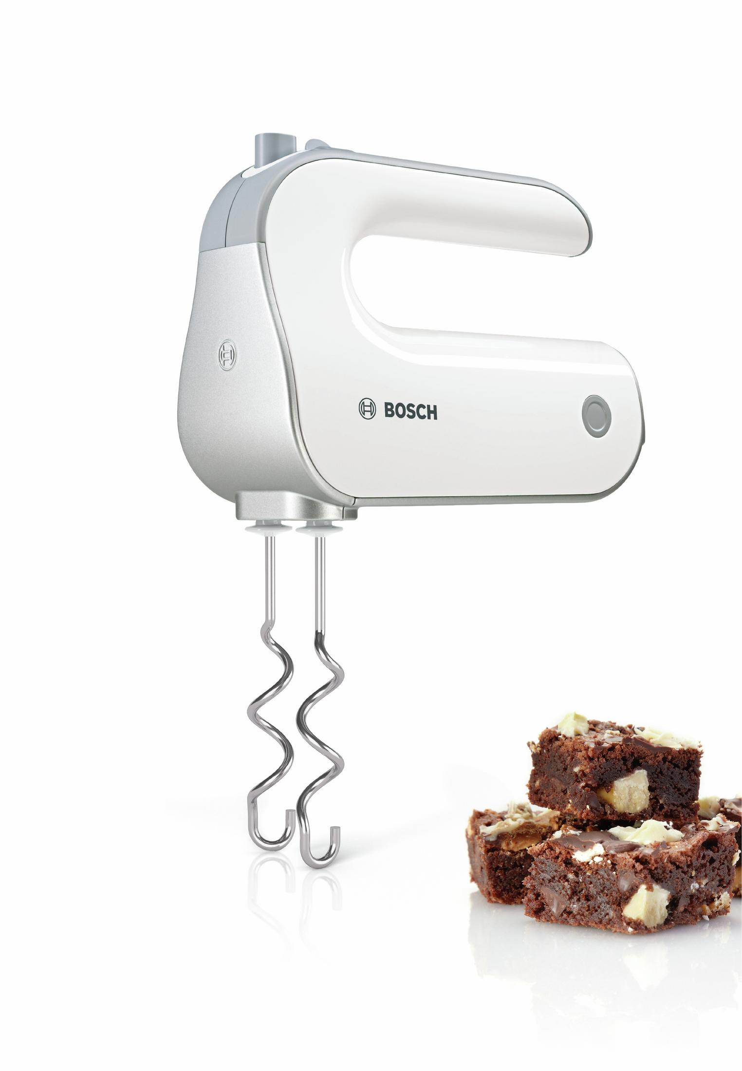 White Bosch hand mixer with a stack of brownies next to it on a white surface.