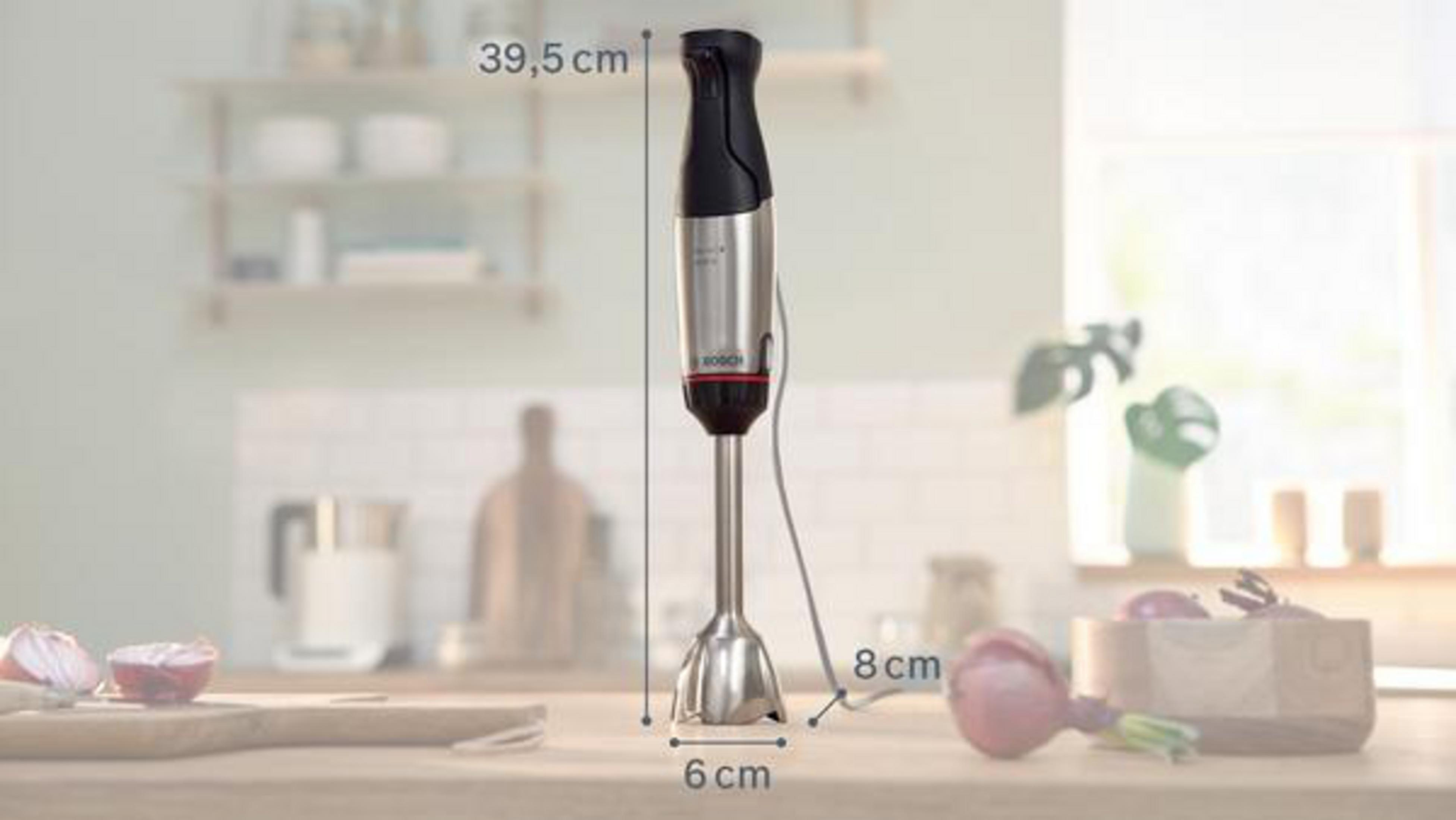 Frullatore a immersione Bosch su superficie in legno con dimensioni. Cipolle e ciotola di legno sullo sfondo sfocato.