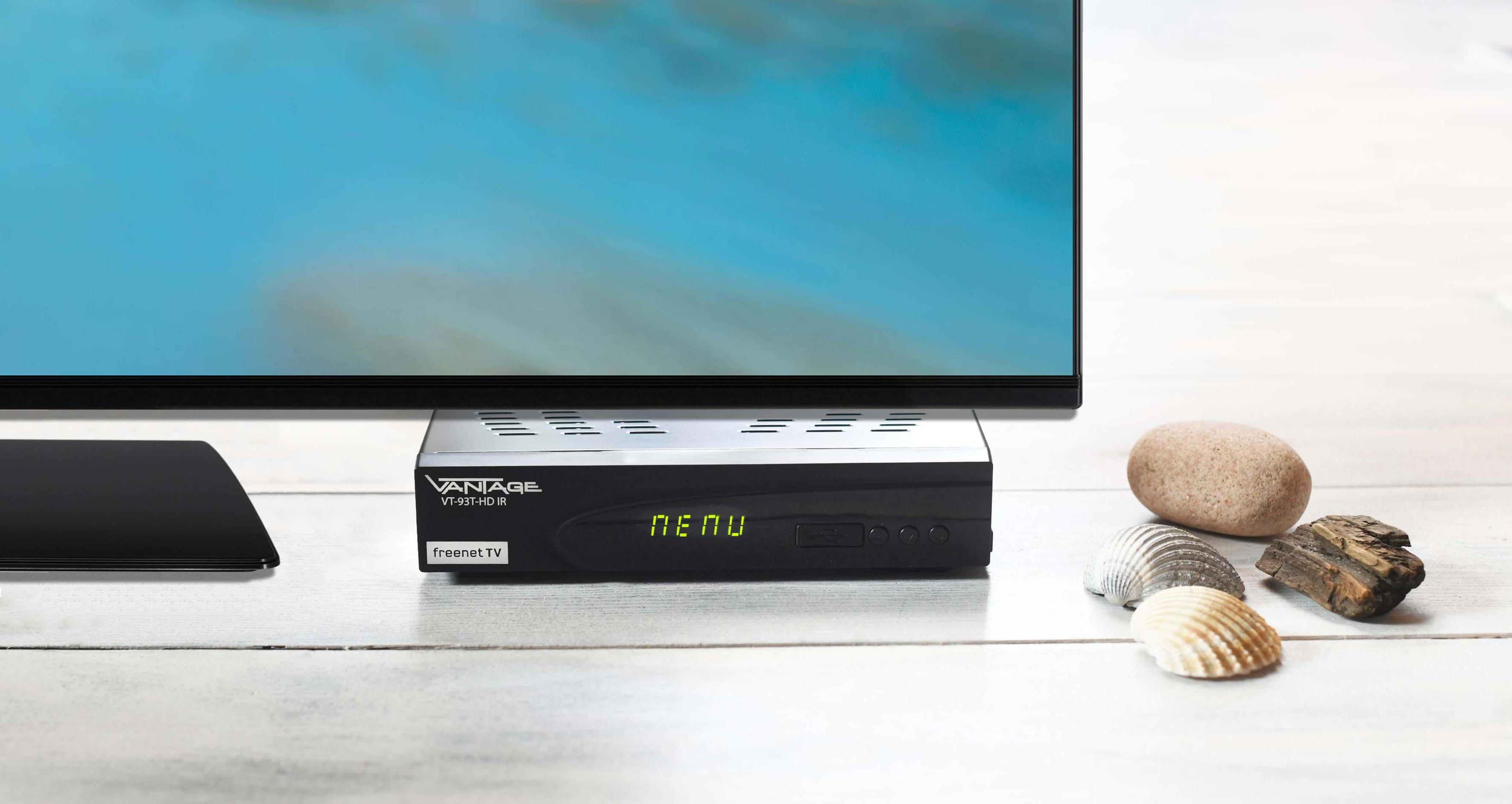 Schwarzer Media-Receiver unter einem Fernseher. Ein paar Muscheln und Steine ​​vor dem Fernseher.