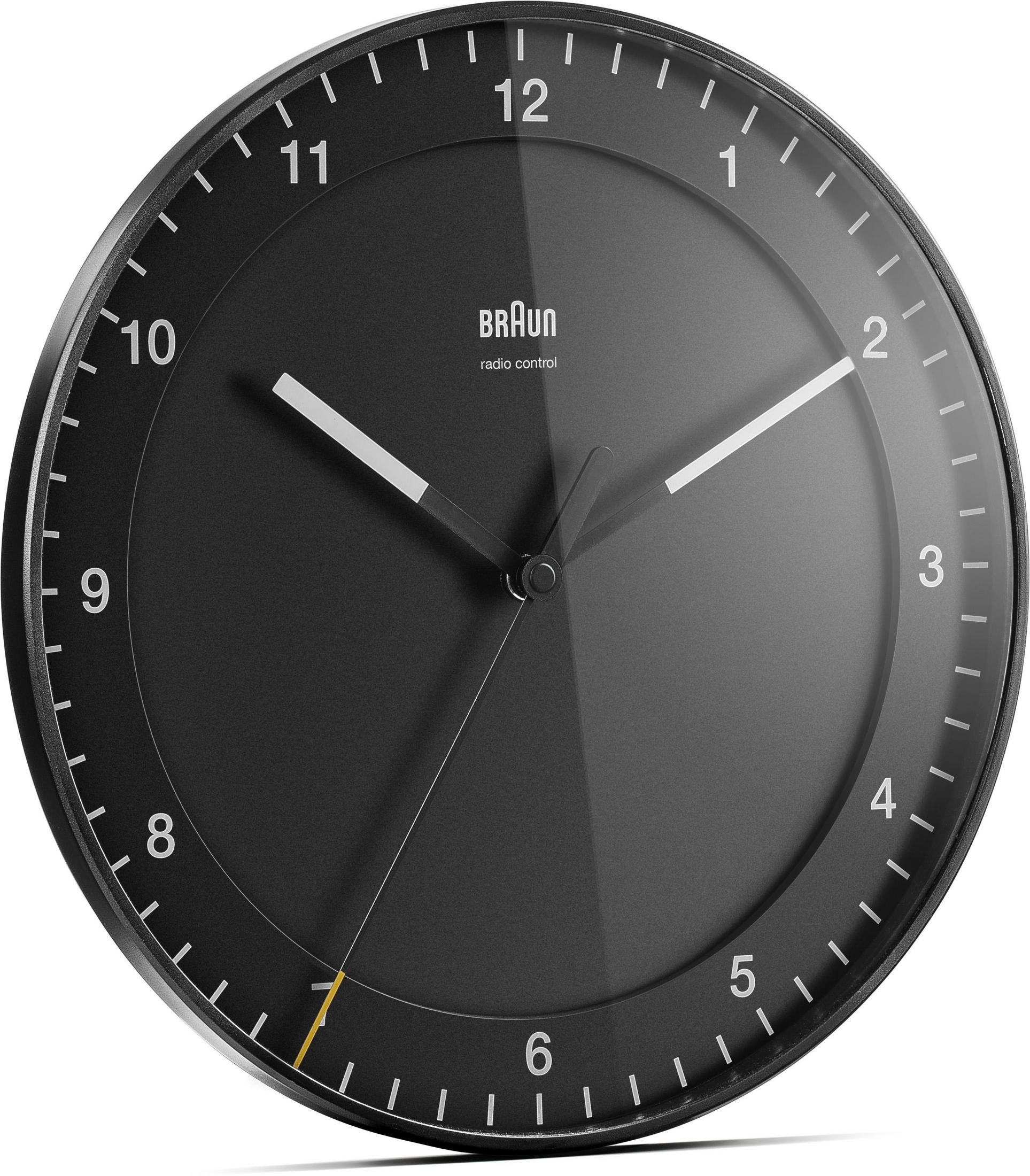Eine schwarze, funkgesteuerte Braun-Uhr. Die Uhr hat weiße Zeiger und Zahlen. Der Hintergrund ist schwarz.