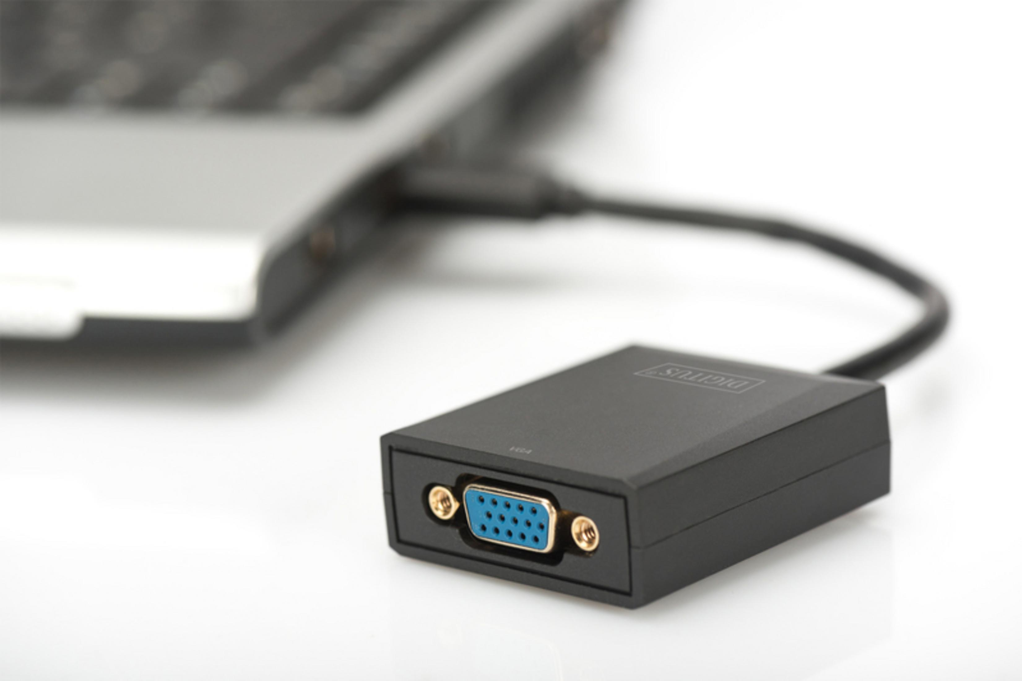 Ein schwarzer VGA-Adapter ist mit einem Laptop verbunden. Der Adapter ist im Fokus.