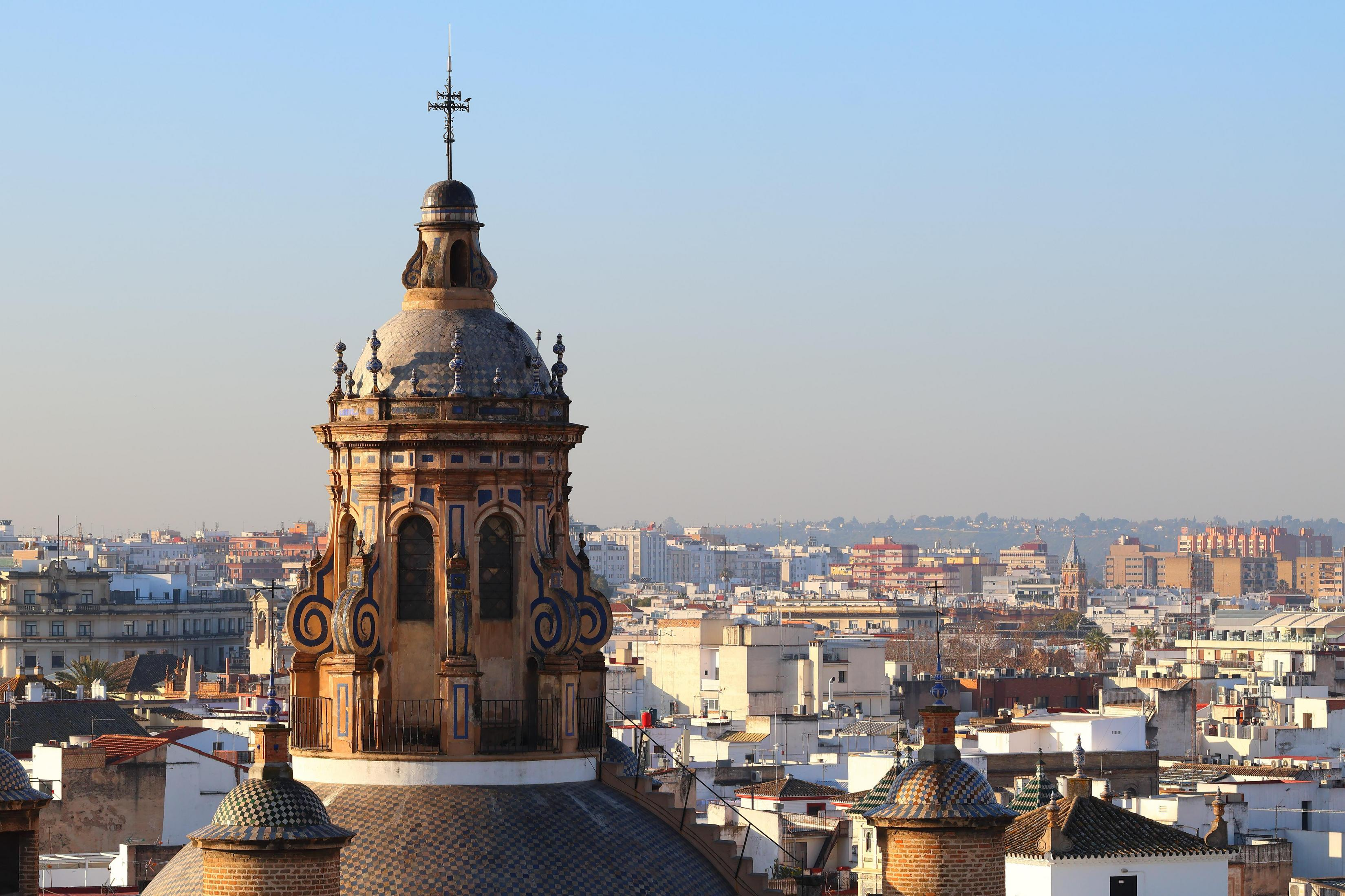 Un paesaggio urbano con una cupola di chiesa in primo piano. Il cielo è sereno.