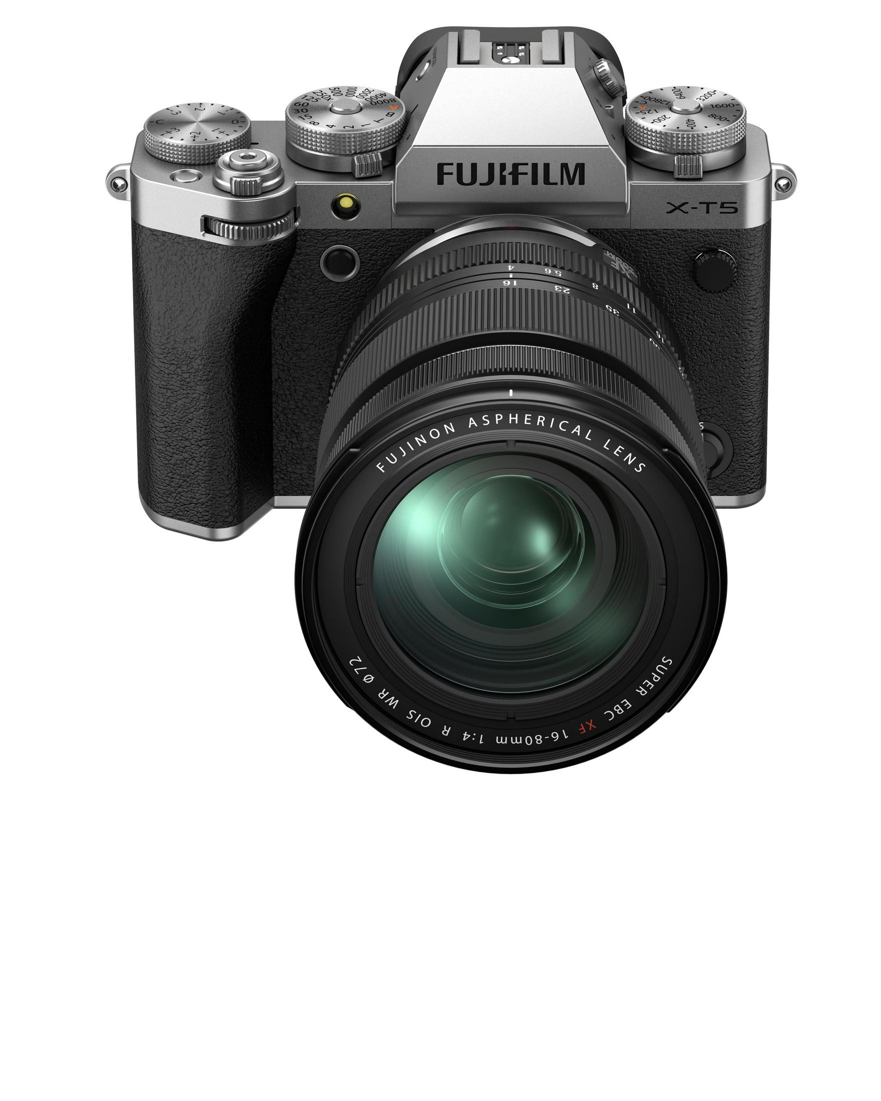 Zilveren en zwarte camera met een lens. De camera heeft veel draaiknoppen aan de bovenkant.