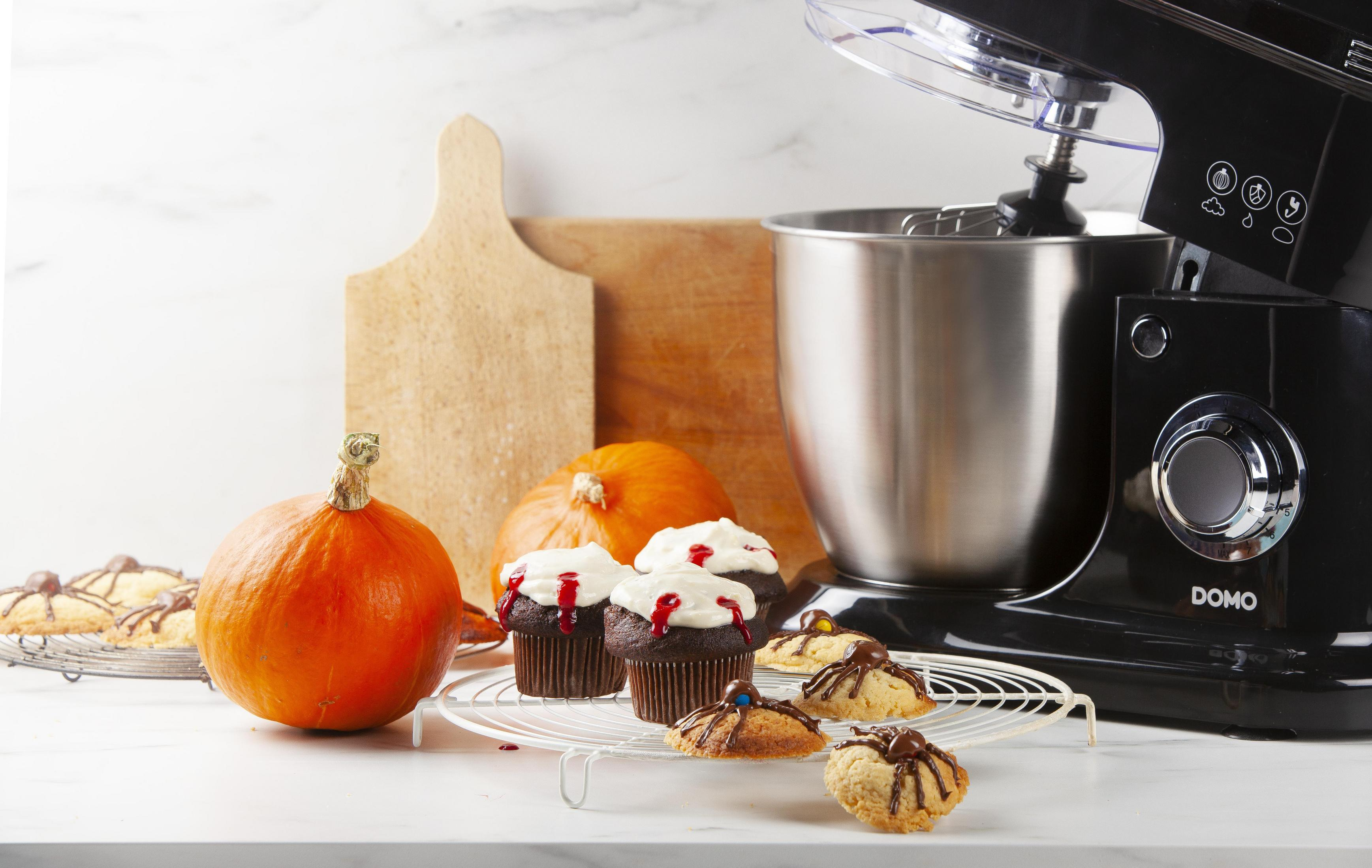 Cupcake di Halloween e zucche vicino a un mixer. Strumenti e ingredienti per la cottura.