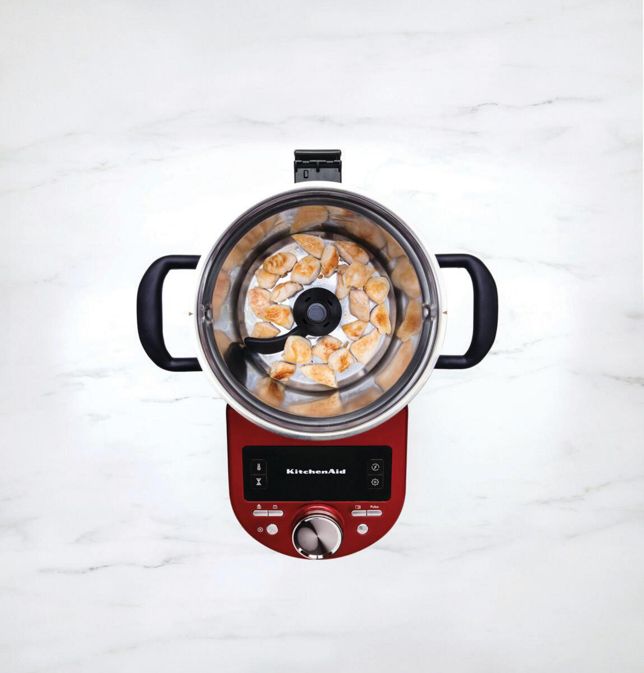 Draufsicht auf einen roten KitchenAid-Foodprozessor, gefüllt mit Essen.