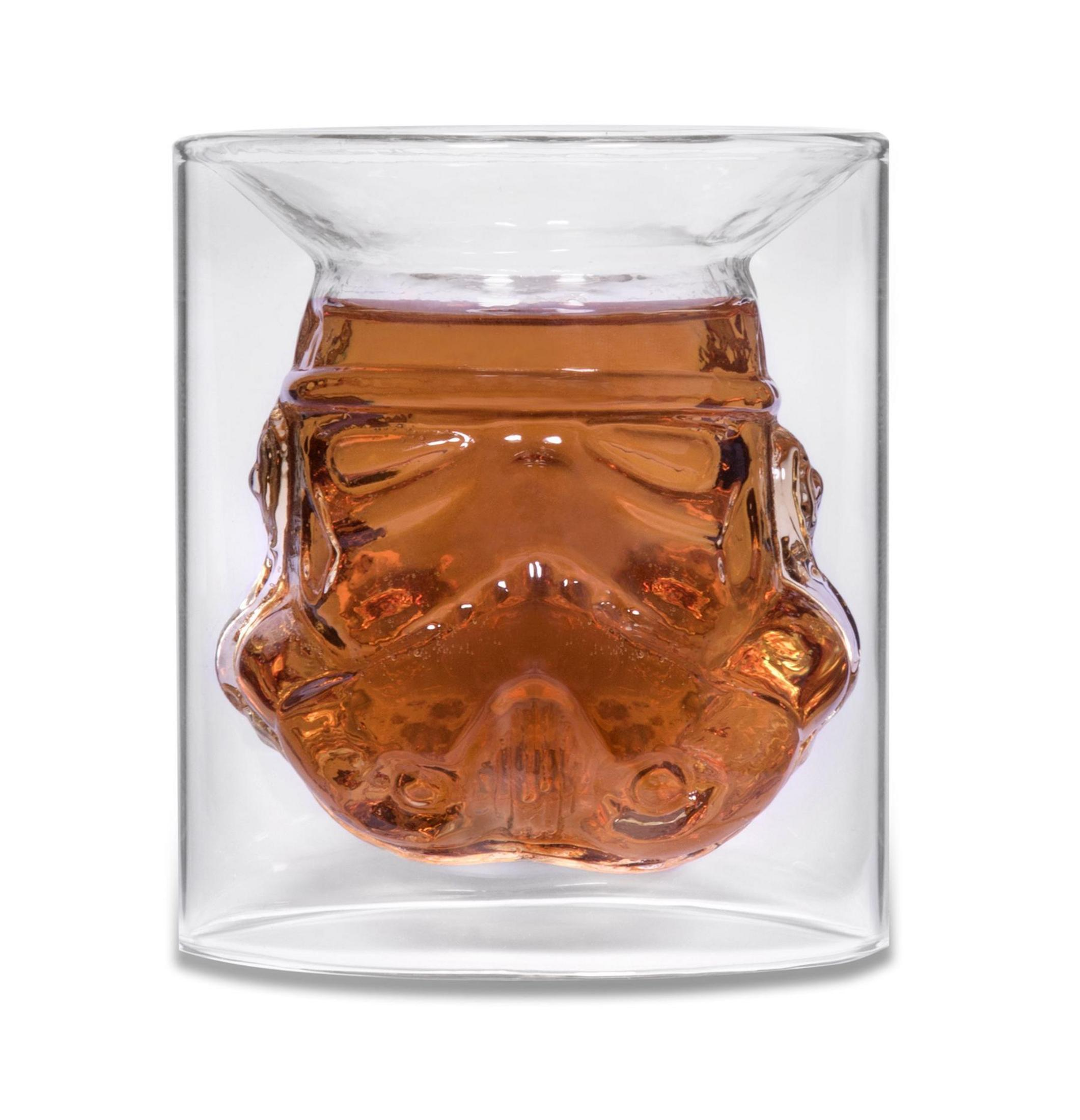 Ein Glas in Form eines Stormtrooper-Helms, gefüllt mit einer braunen Flüssigkeit.