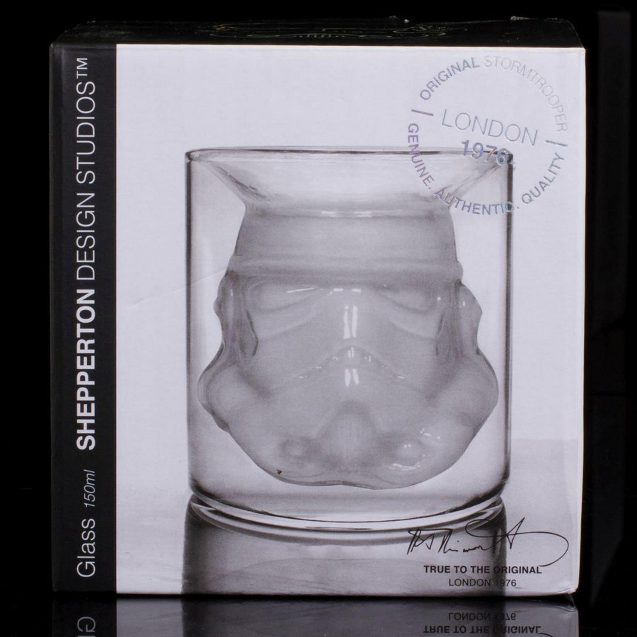 Sturmtruppler-Kopf-Glas in einer Schachtel. Das Glas ist klar, die Schachtel hat Text und Logo.