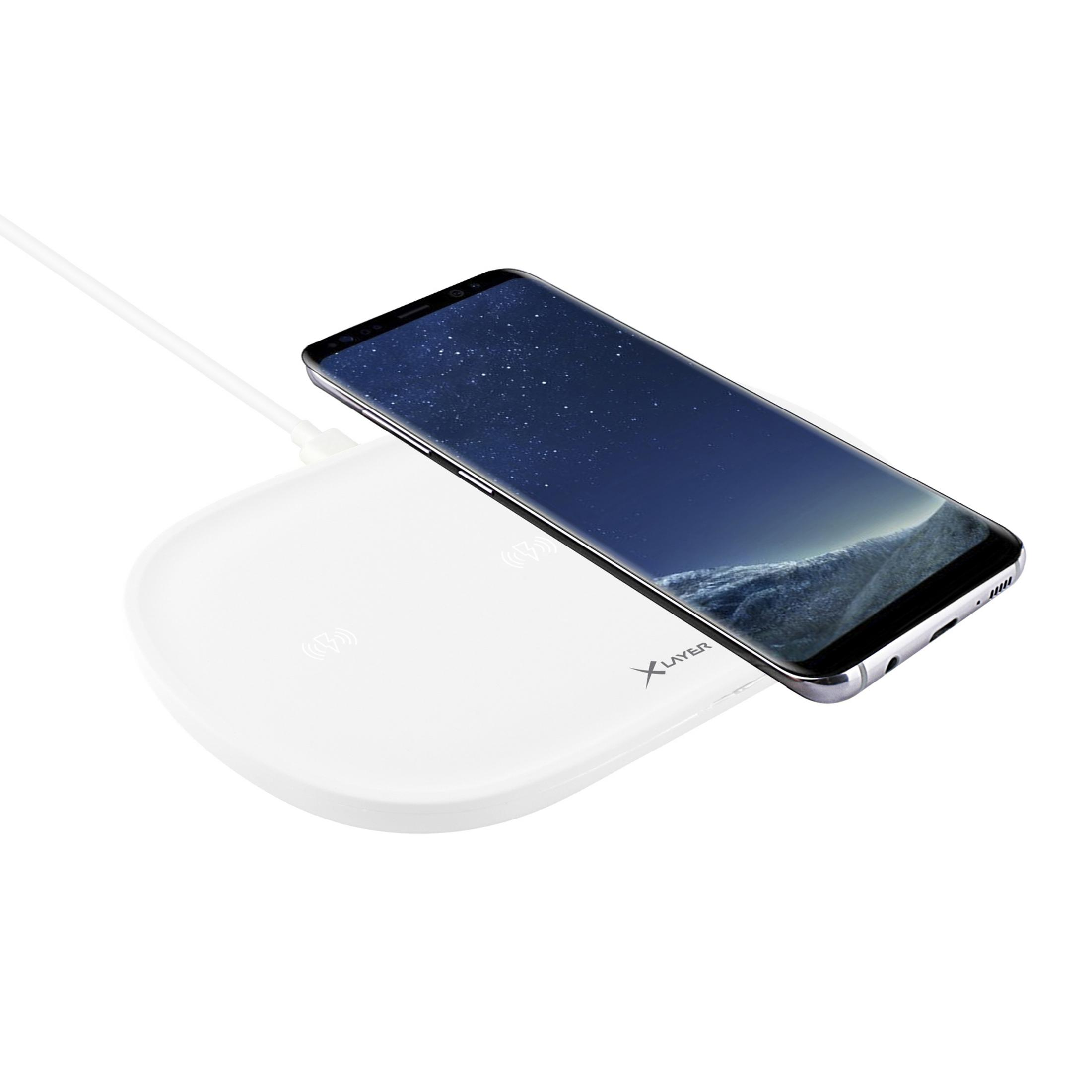 Weißes kabelloses Ladepad mit Smartphone darauf, verbunden durch ein Kabel.
