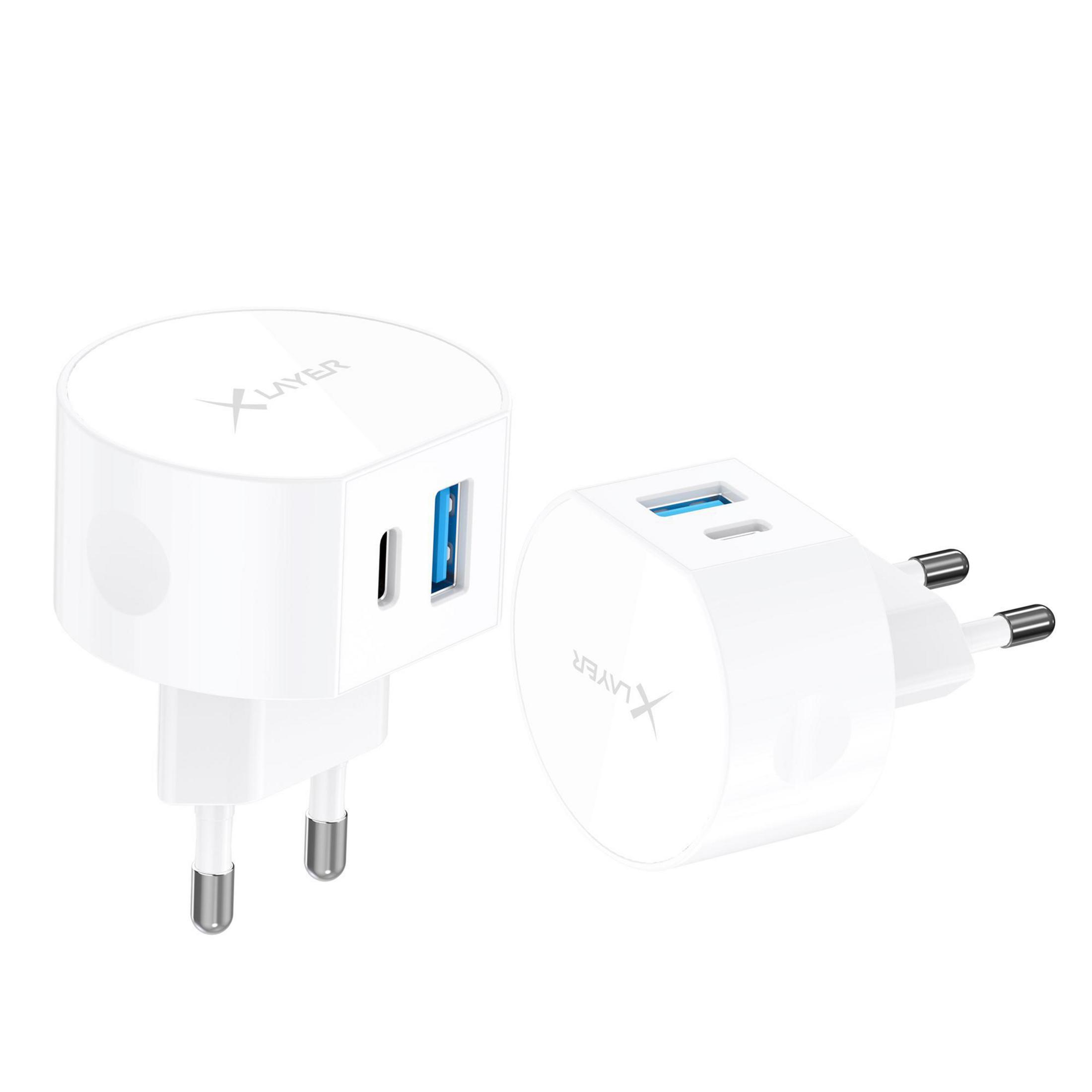 Zwei weiße Ladegeräte mit zwei USB-Anschlüssen, XLayer-Logo und zweipoligen Steckern.