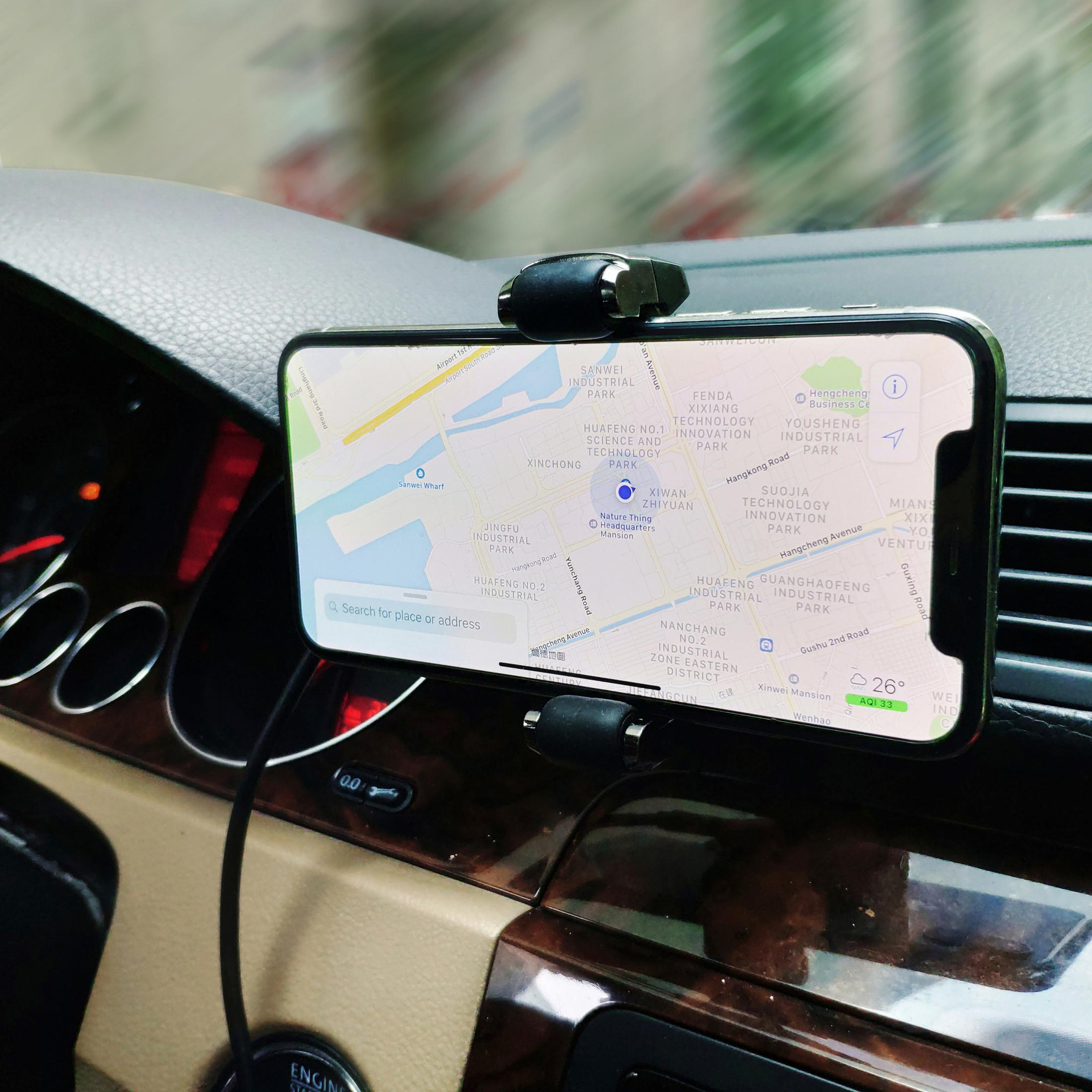 Téléphone sur un support de voiture affichant une carte. Le tableau de bord est marron. La scène est dans une voiture.