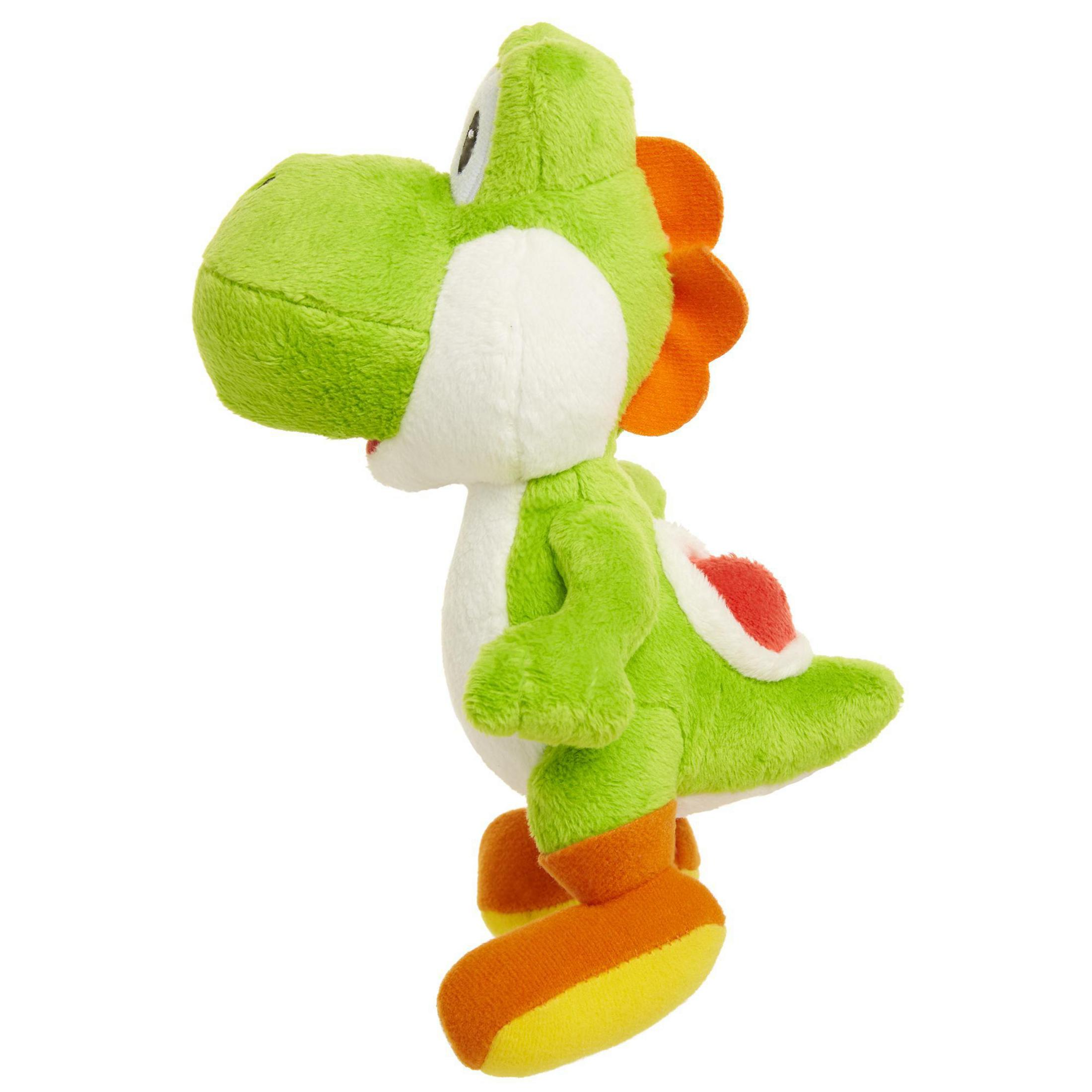 Grünes Yoshi-Stofftier. Es hat einen weißen Bauch, orangefarbene Schuhe und einen roten Panzer.