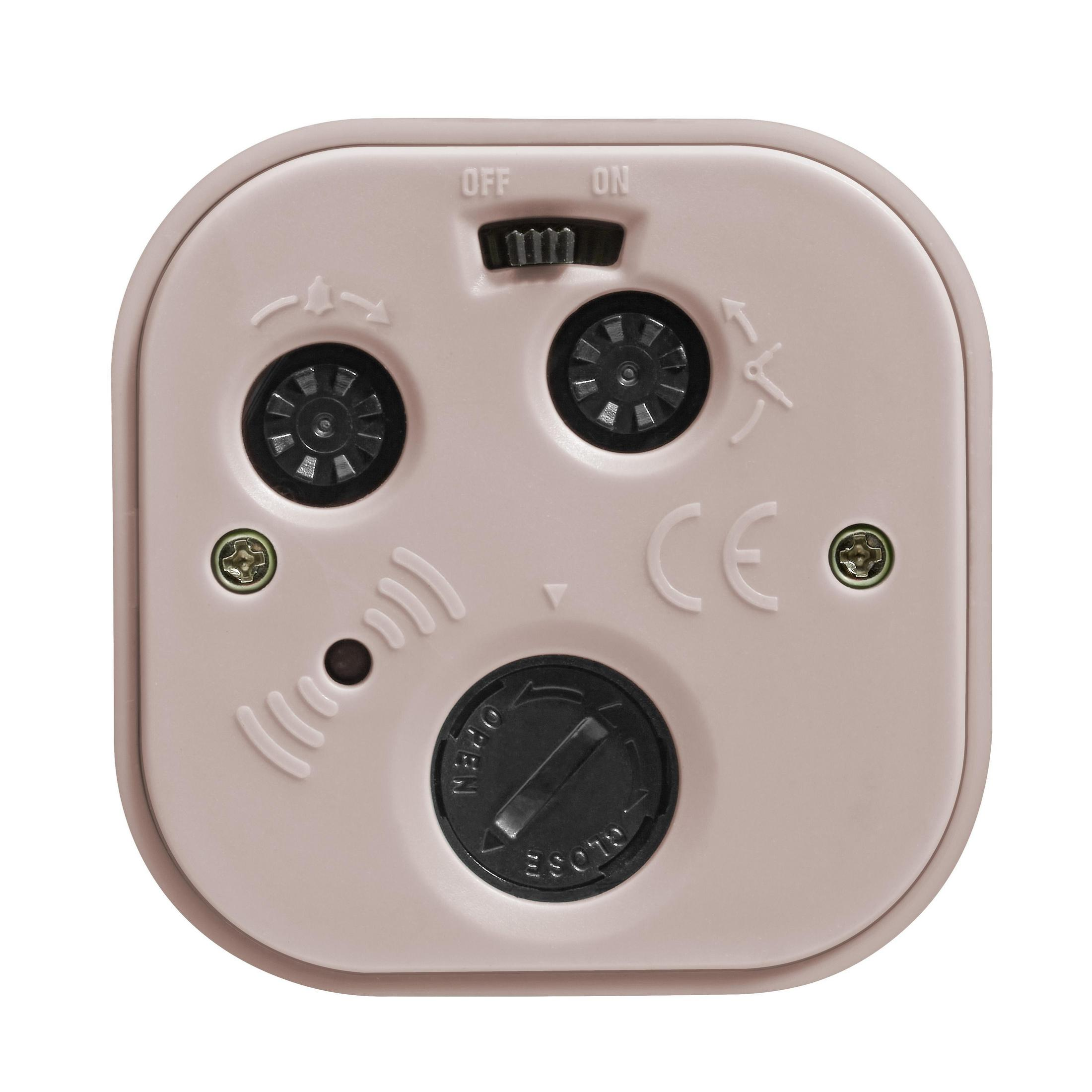 Dos d'un appareil électronique rose, avec boutons, vis et compartiment à piles.