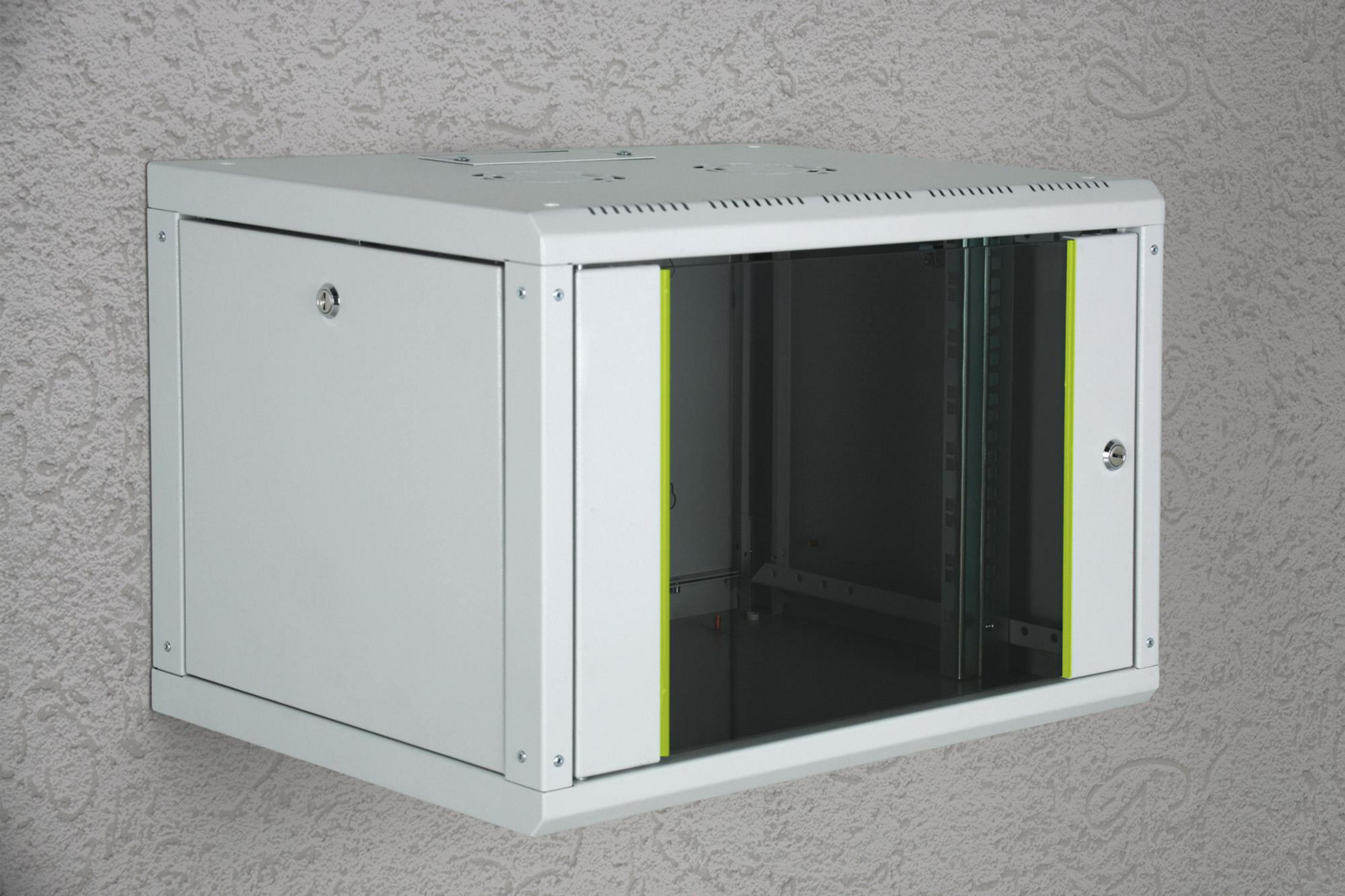 Ein weißer, an der Wand montierter Netzwerkschrank. Er hat eine Glastür und ist an einer gemusterten Wand angebracht.