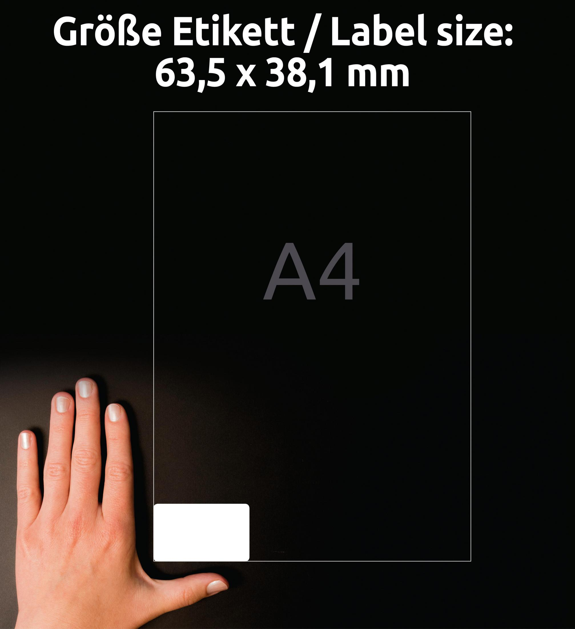 A4-Papier mit Etikettengrößenangaben auf schwarzem Untergrund. Eine Hand liegt daneben.