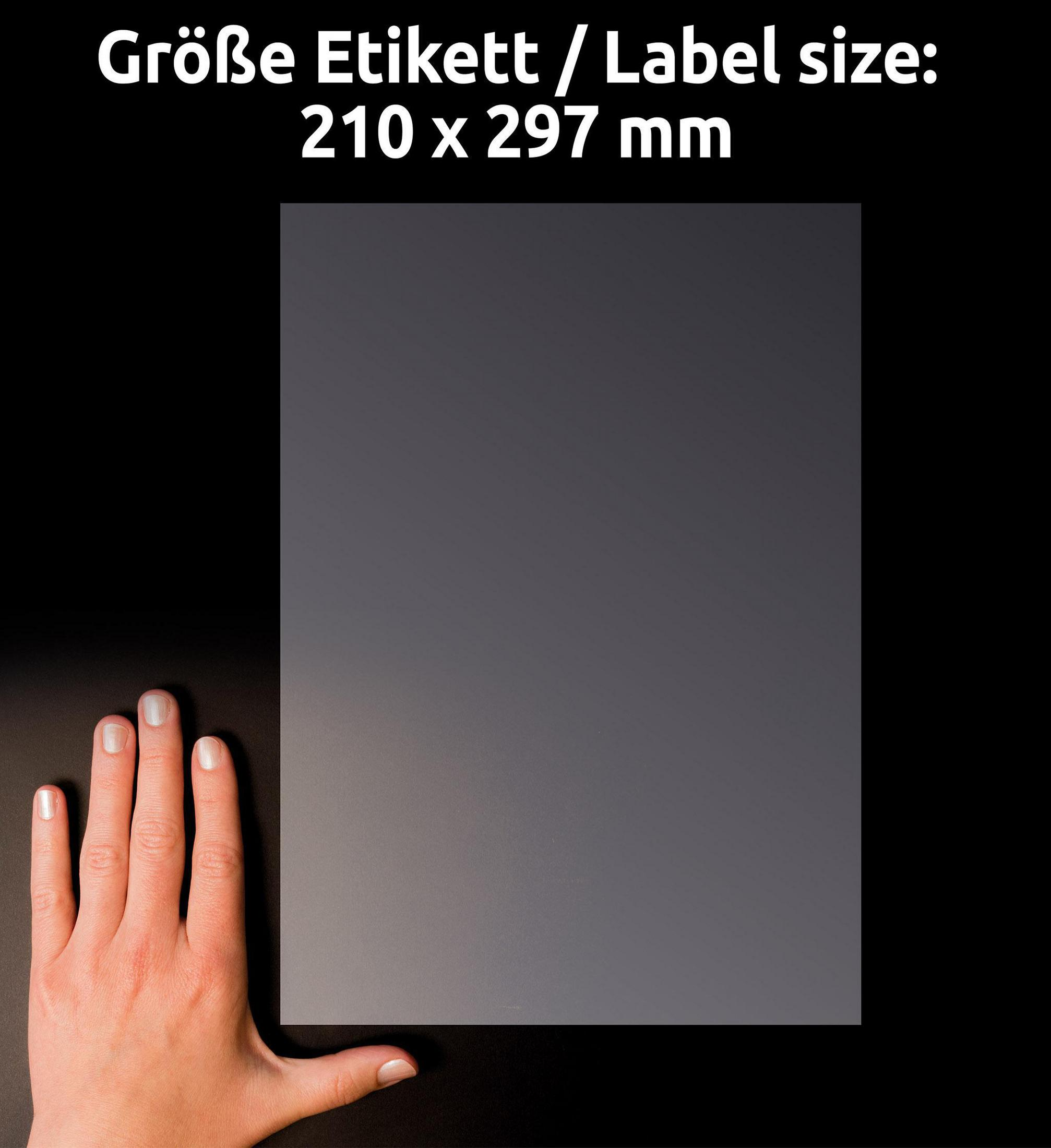 Ein Blatt graues Papier mit Text darüber, der die Größe angibt: 210 x 297 mm. Daneben liegt eine Hand.