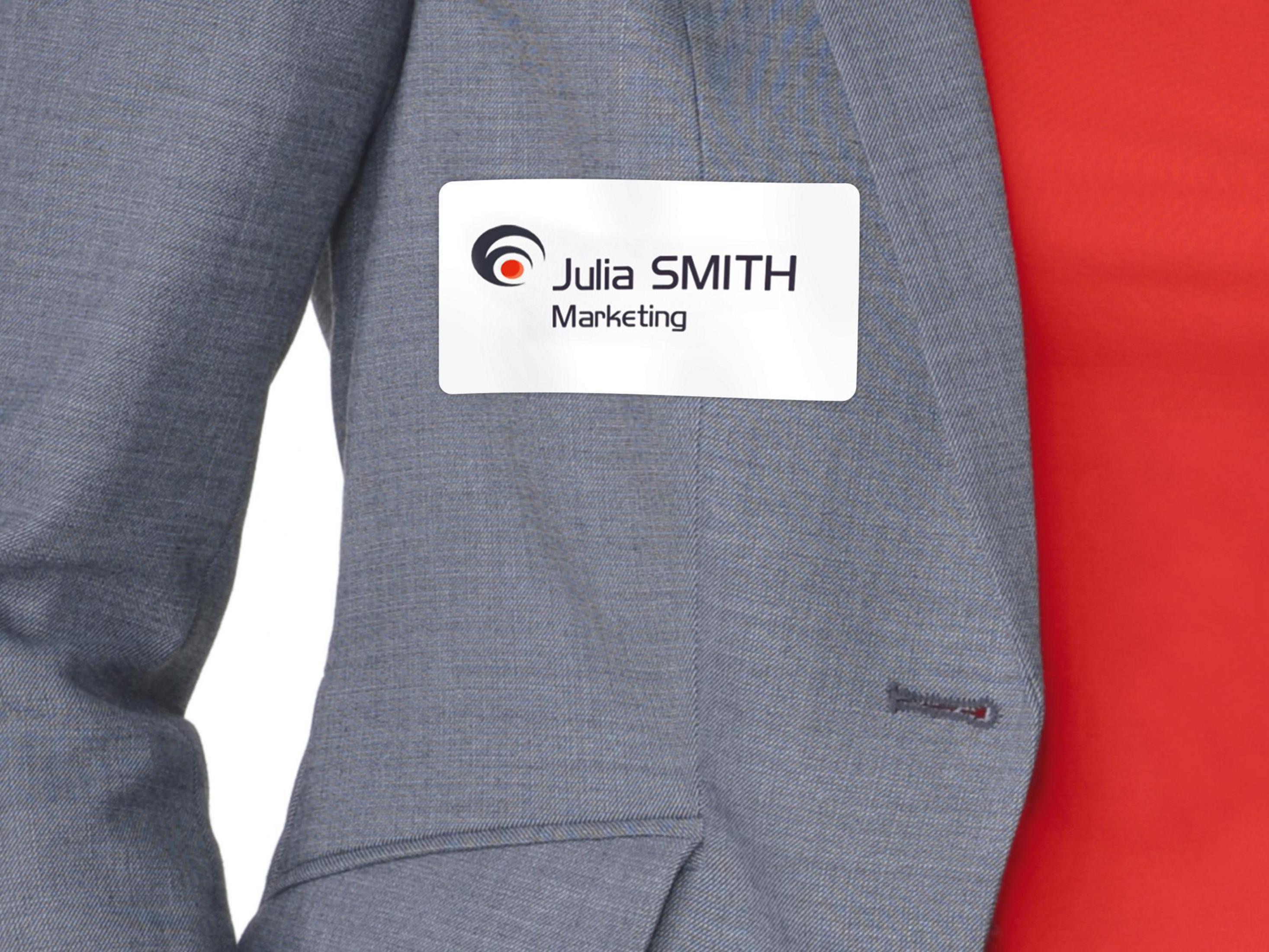 Namensschild auf grauem Anzug. Es lautet 'Julia SMITH, Marketing'.