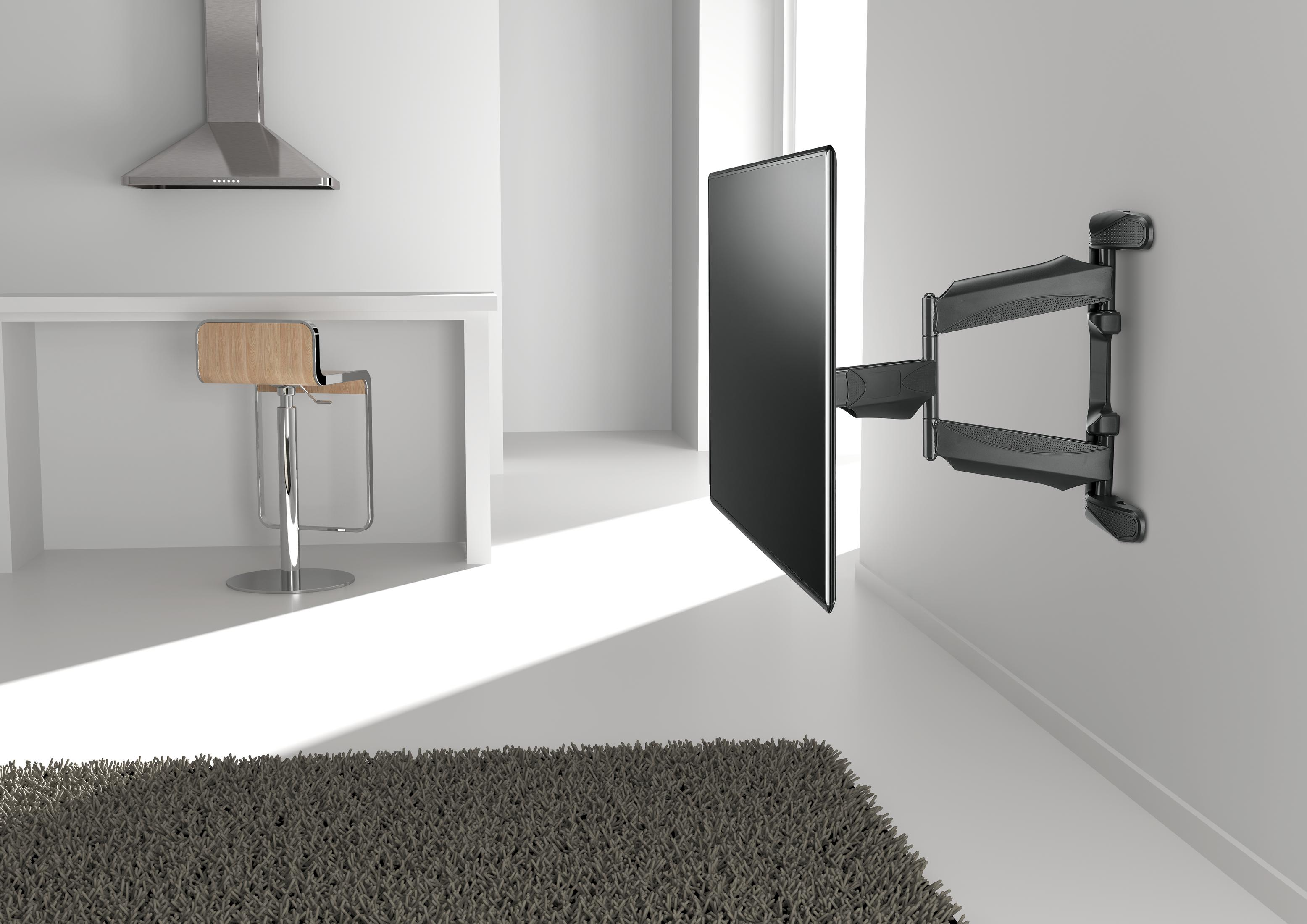 Telewizor zamontowany na ścianie na przegubowym ramieniu, z białą ścianą i jasno brązową podłogą.