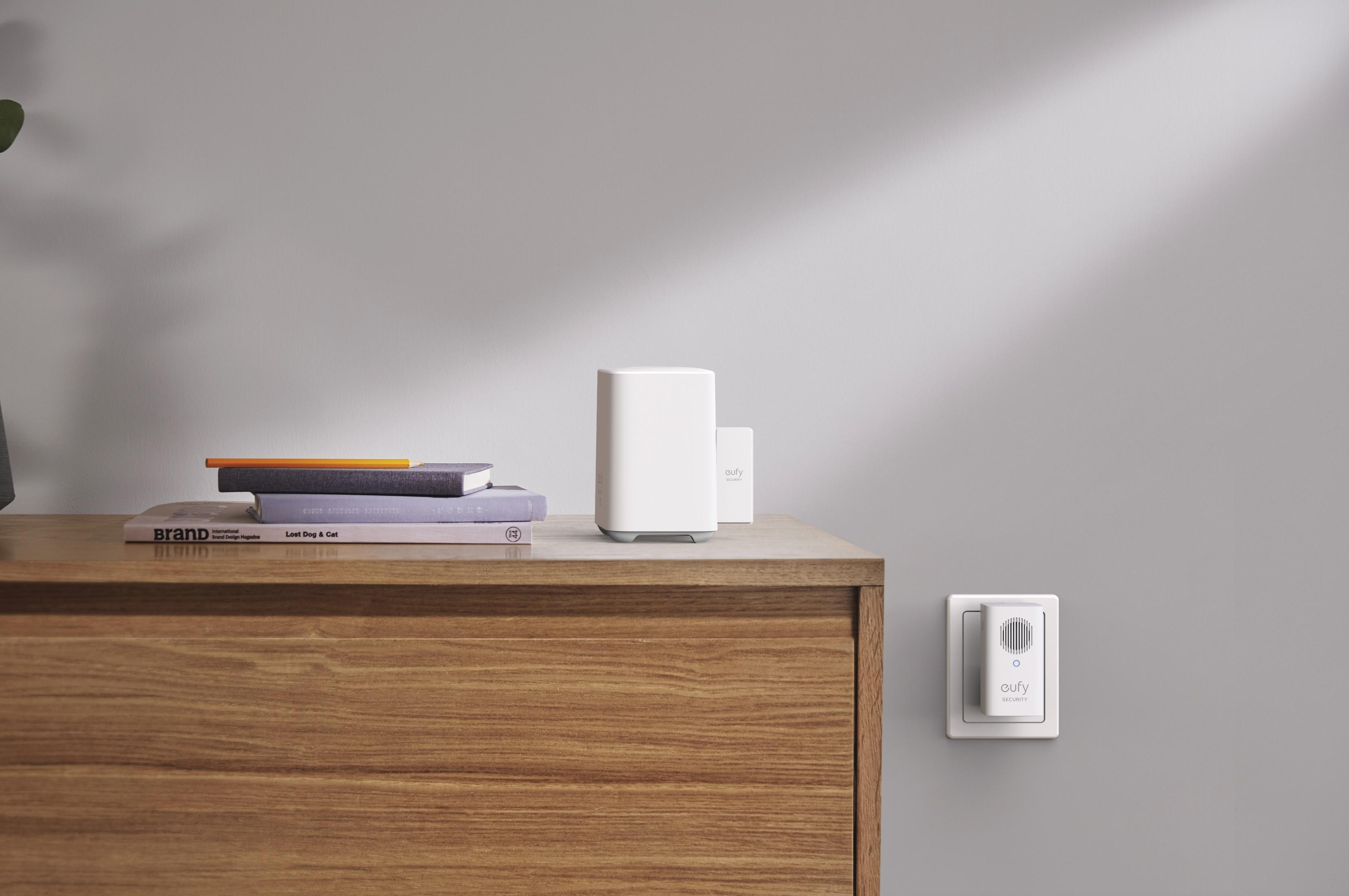 Ein weißes Smart-Home-Gerät auf einer Holzoberfläche, mit Wandgerät.