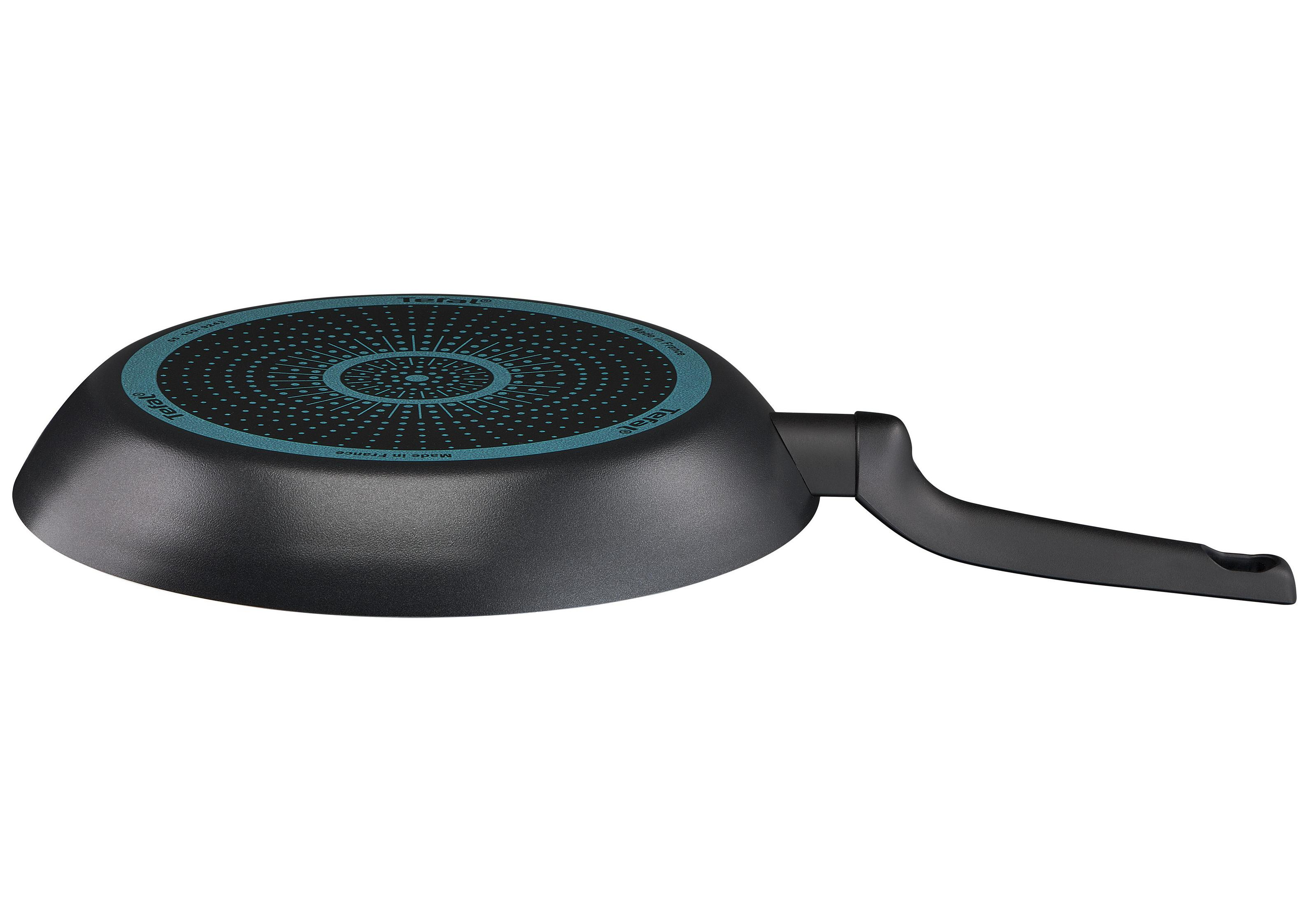 Spód czarnej patelni, niebieski wzór na spodzie, czarny uchwyt.
