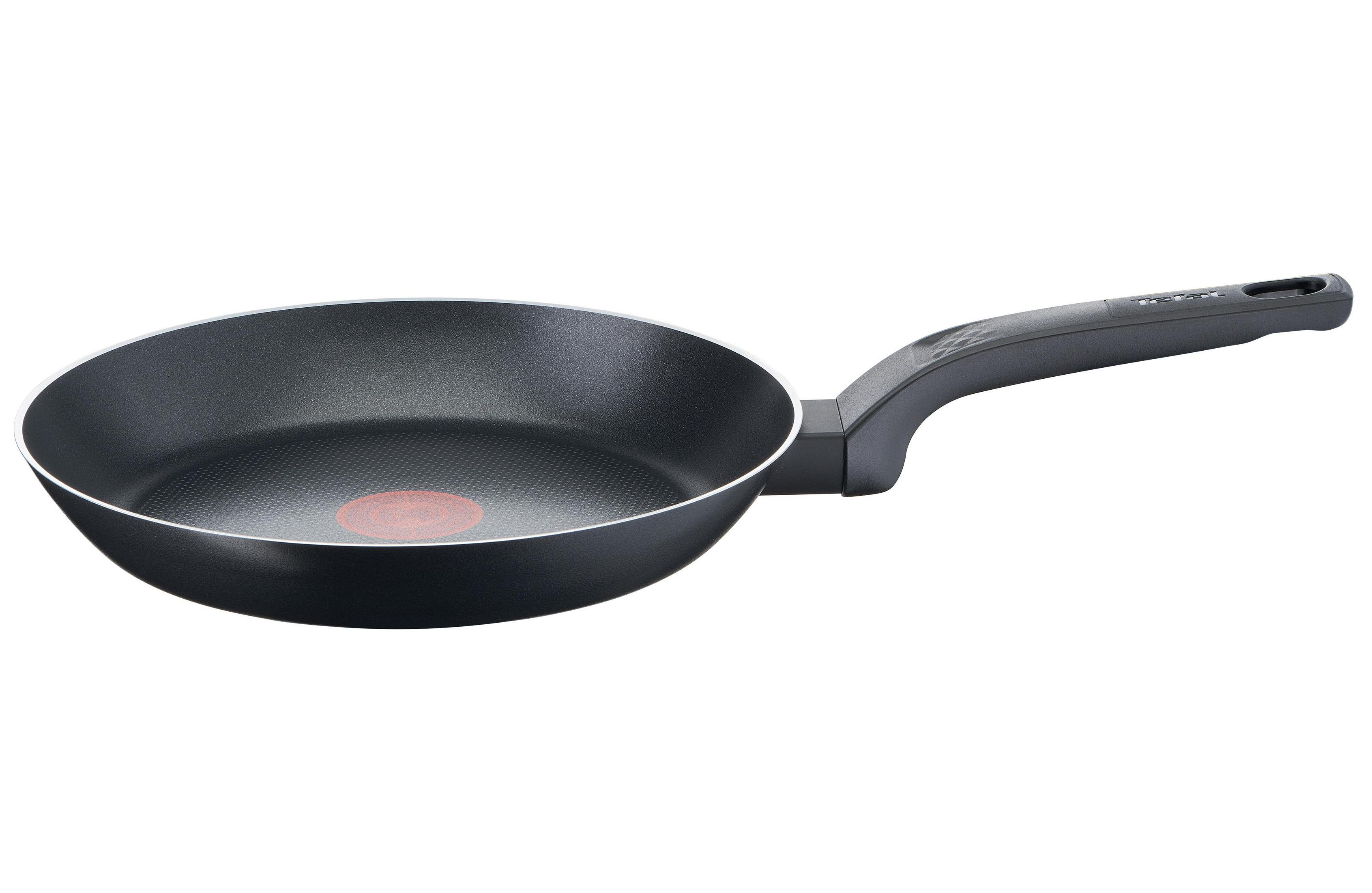 Czarna patelnia z uchwytem i czerwoną kropką pośrodku. Białe tło.