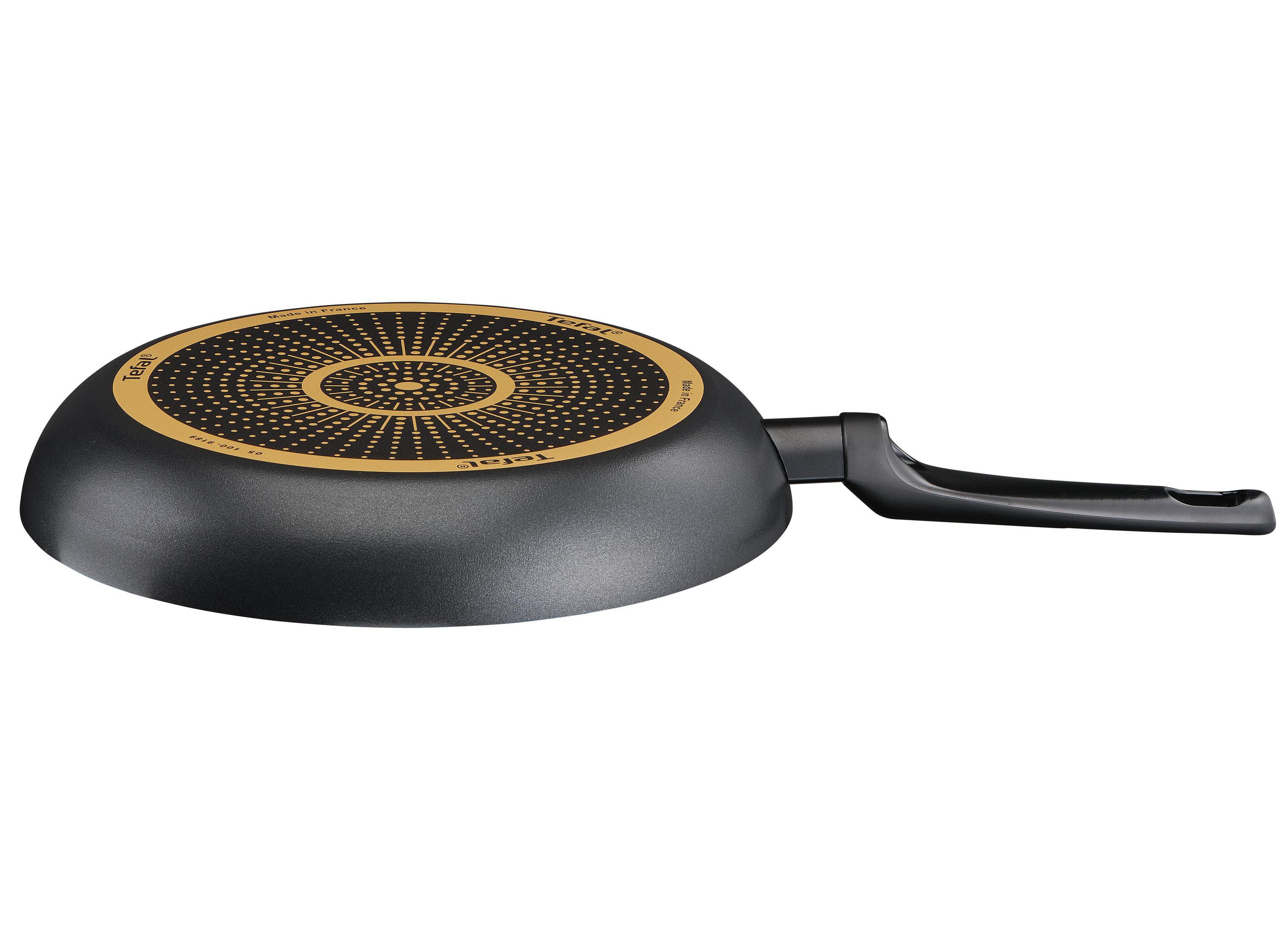 Fond de poêle noir avec un motif doré et une poignée. Texte Tefal. Fond blanc.
