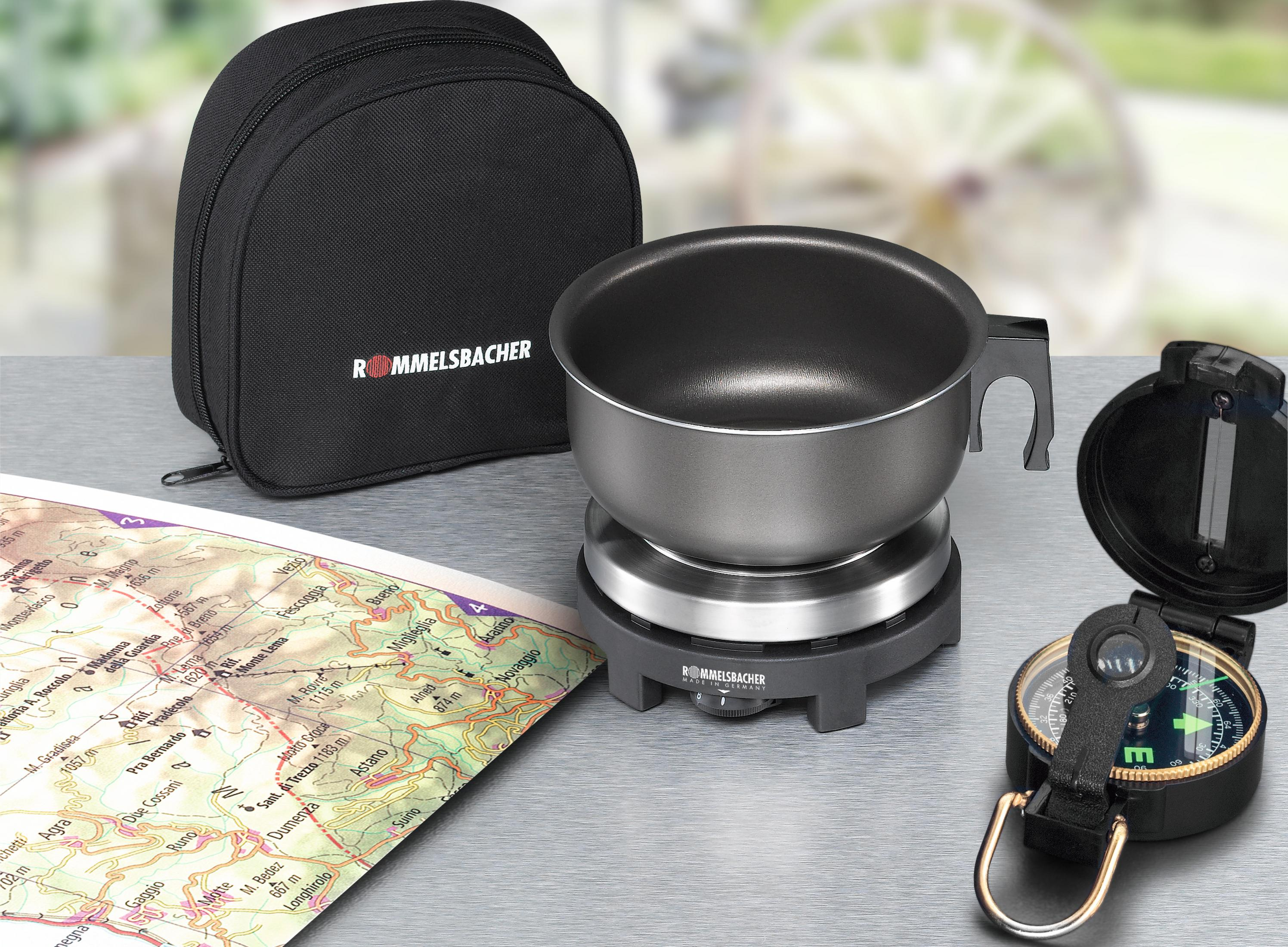 Kuchenka kempingowa z akcesoriami na stole, z mapą i kompasem.