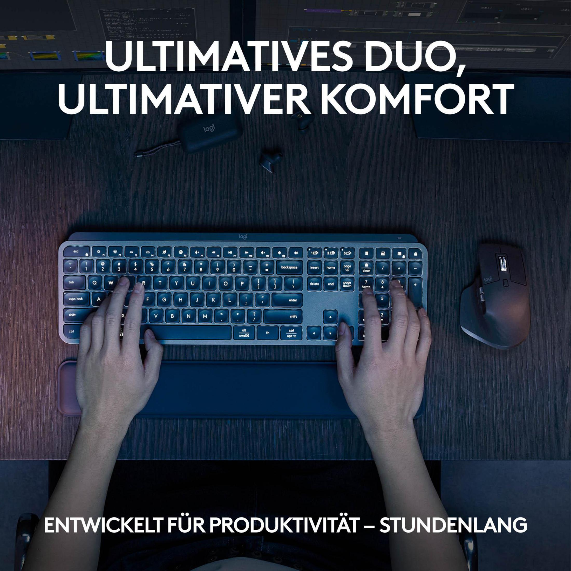 Dłonie na klawiaturze i myszy na drewnianym biurku z tekstem powyżej, klawiatura ma podpórkę pod nadgarstek.