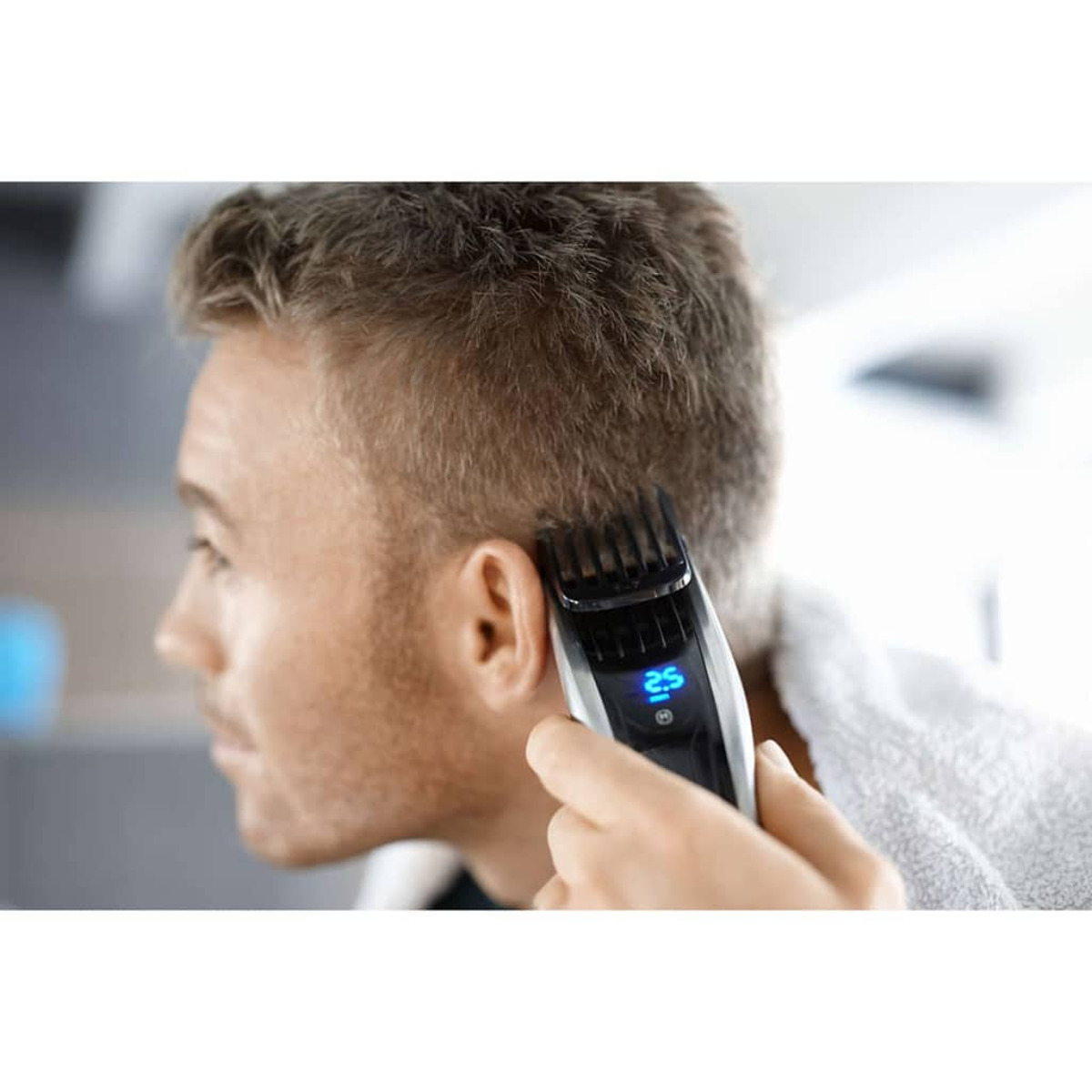Hombre cortándose el pelo con una máquina cortapelos.