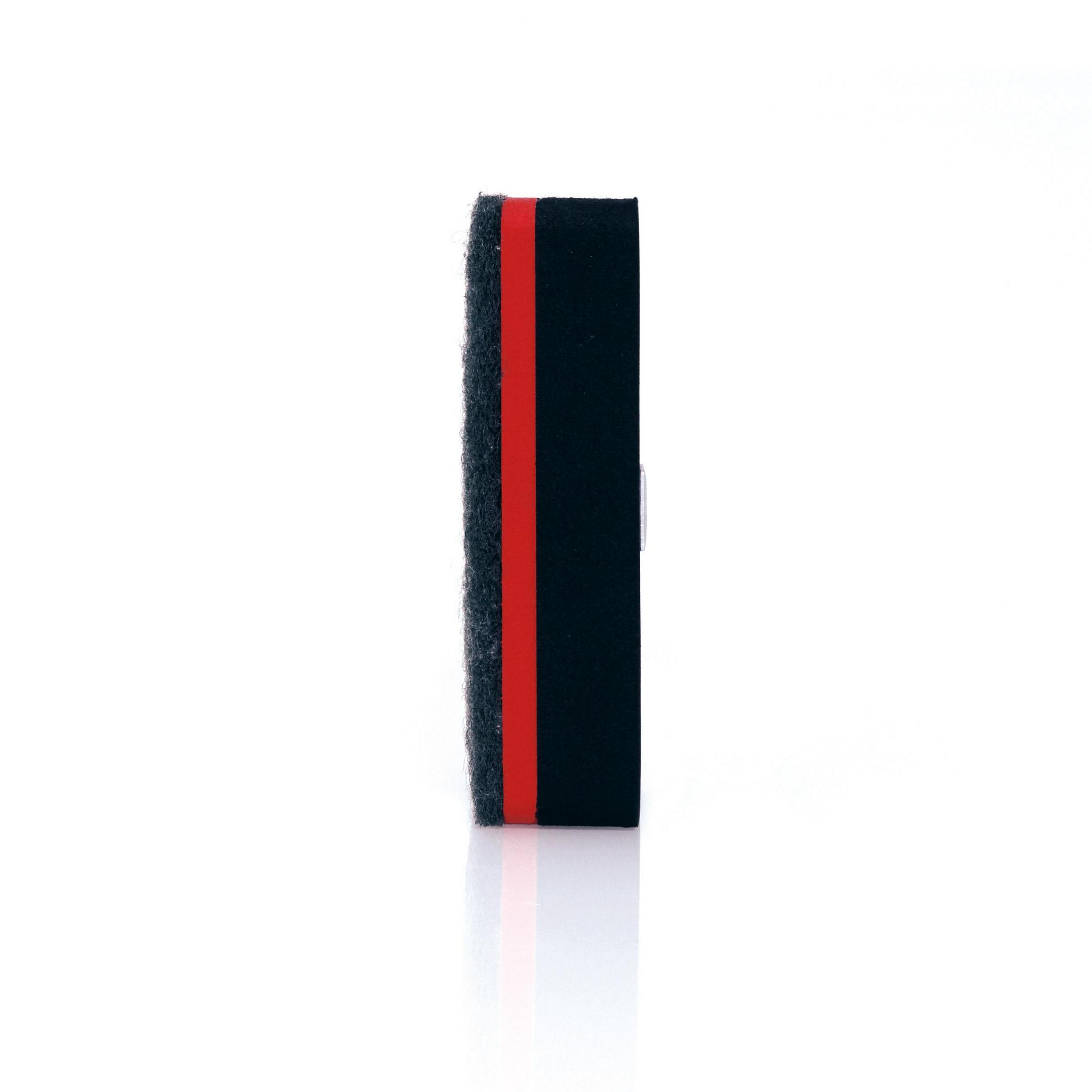 Ein schwarzes und rotes Reinigungspad mit rotem Streifen, isoliert auf weißem Hintergrund.
