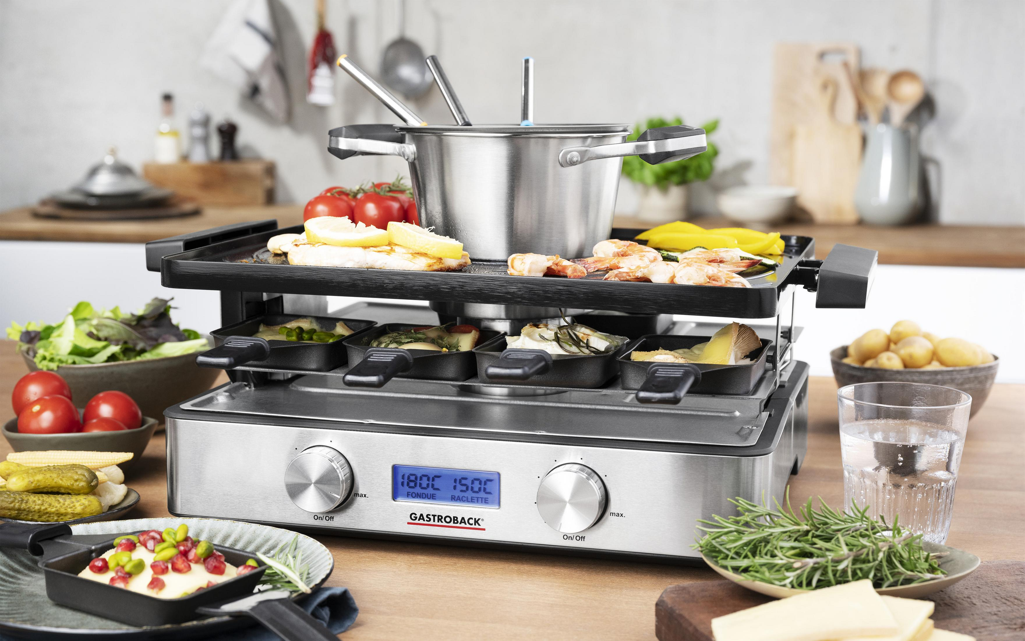 Griglia raclette con ingredienti, cibo sui vassoi, una pentola e un display digitale.