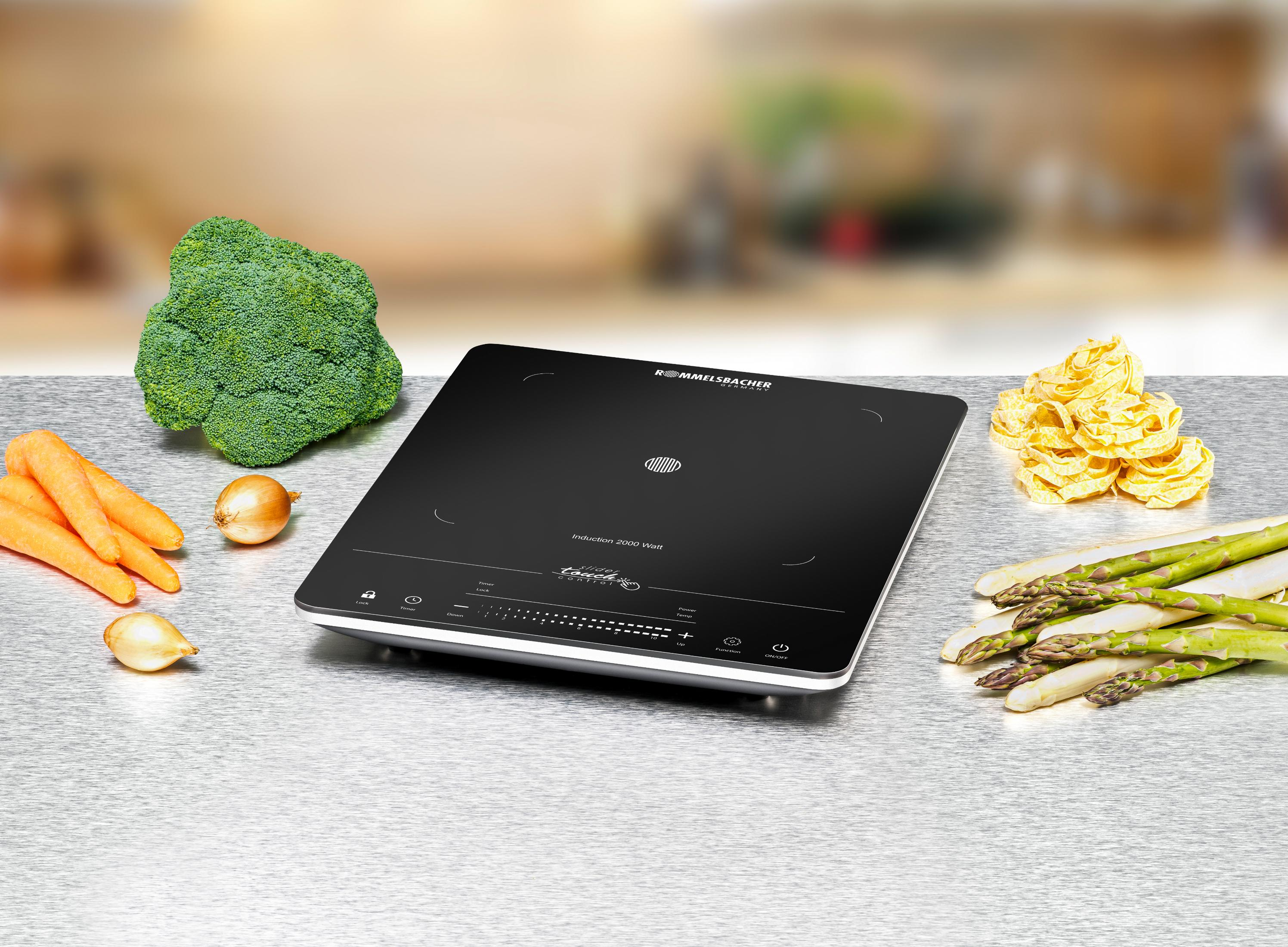 Płyta indukcyjna z warzywami na powierzchni ze stali nierdzewnej.