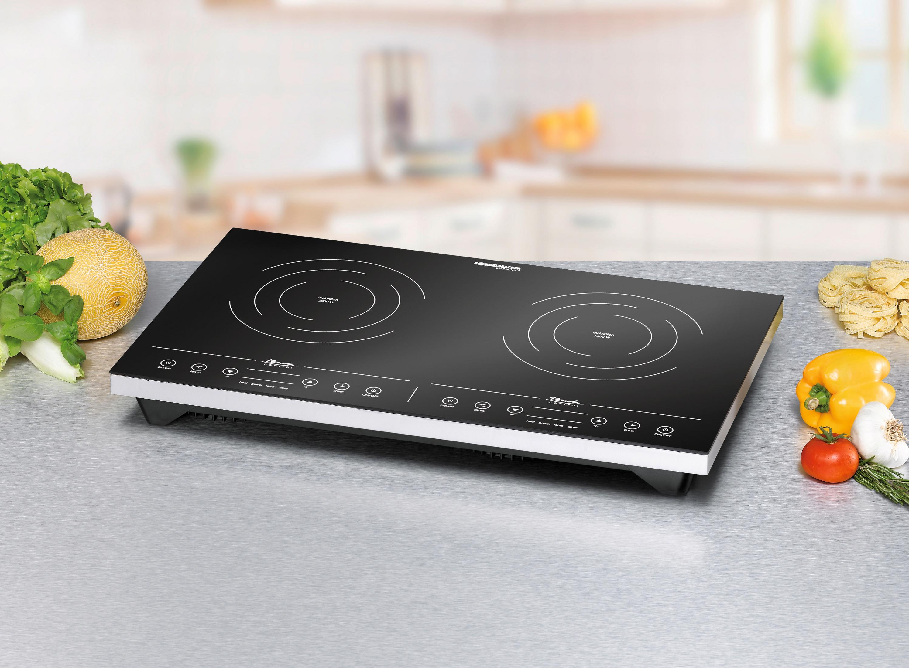 Czarna płyta indukcyjna z przygotowaniem jedzenia z boku. Ma dwie strefy gotowania.
