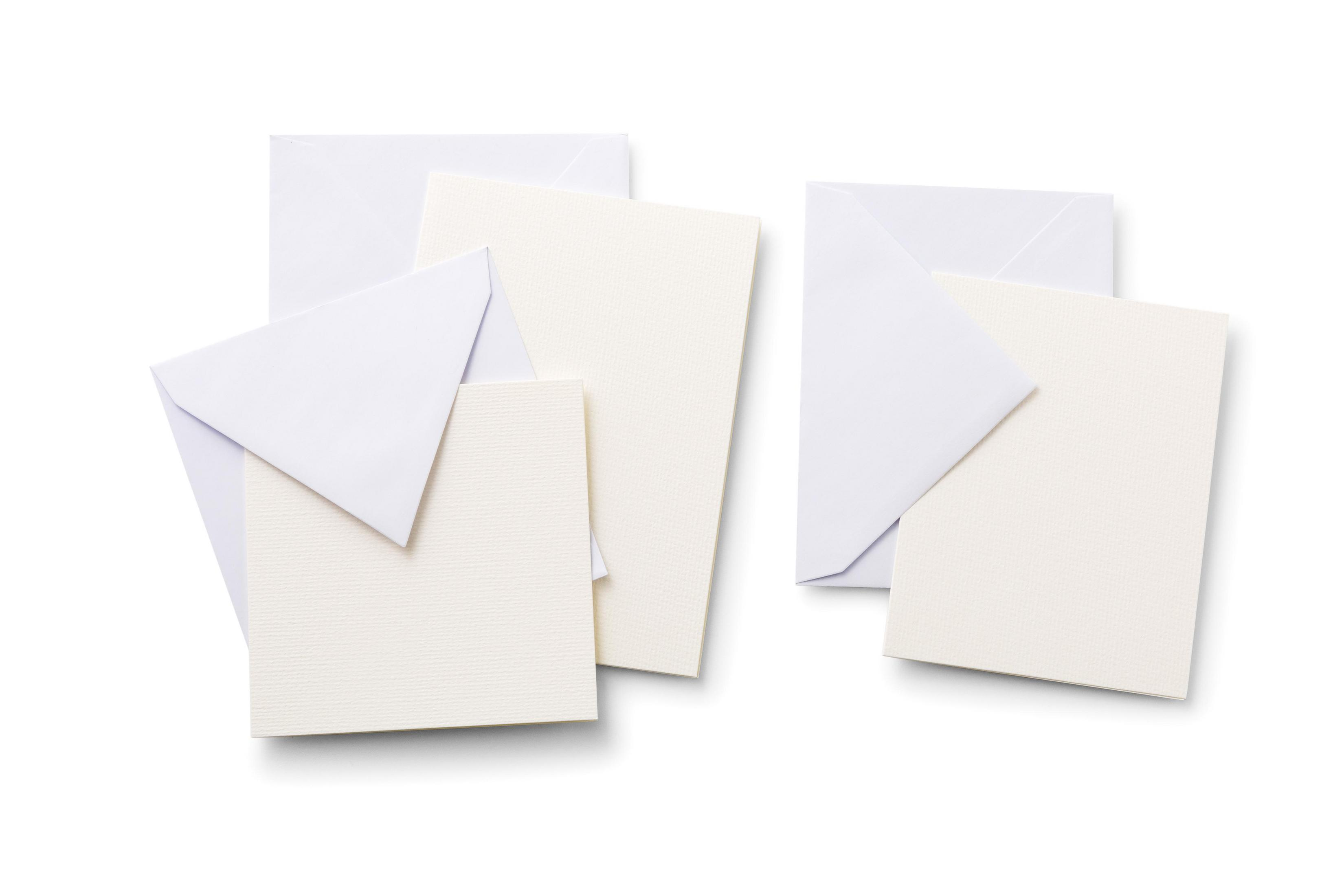 Ein Stapel weißer Umschläge, Karten und Papier auf weißem Hintergrund.