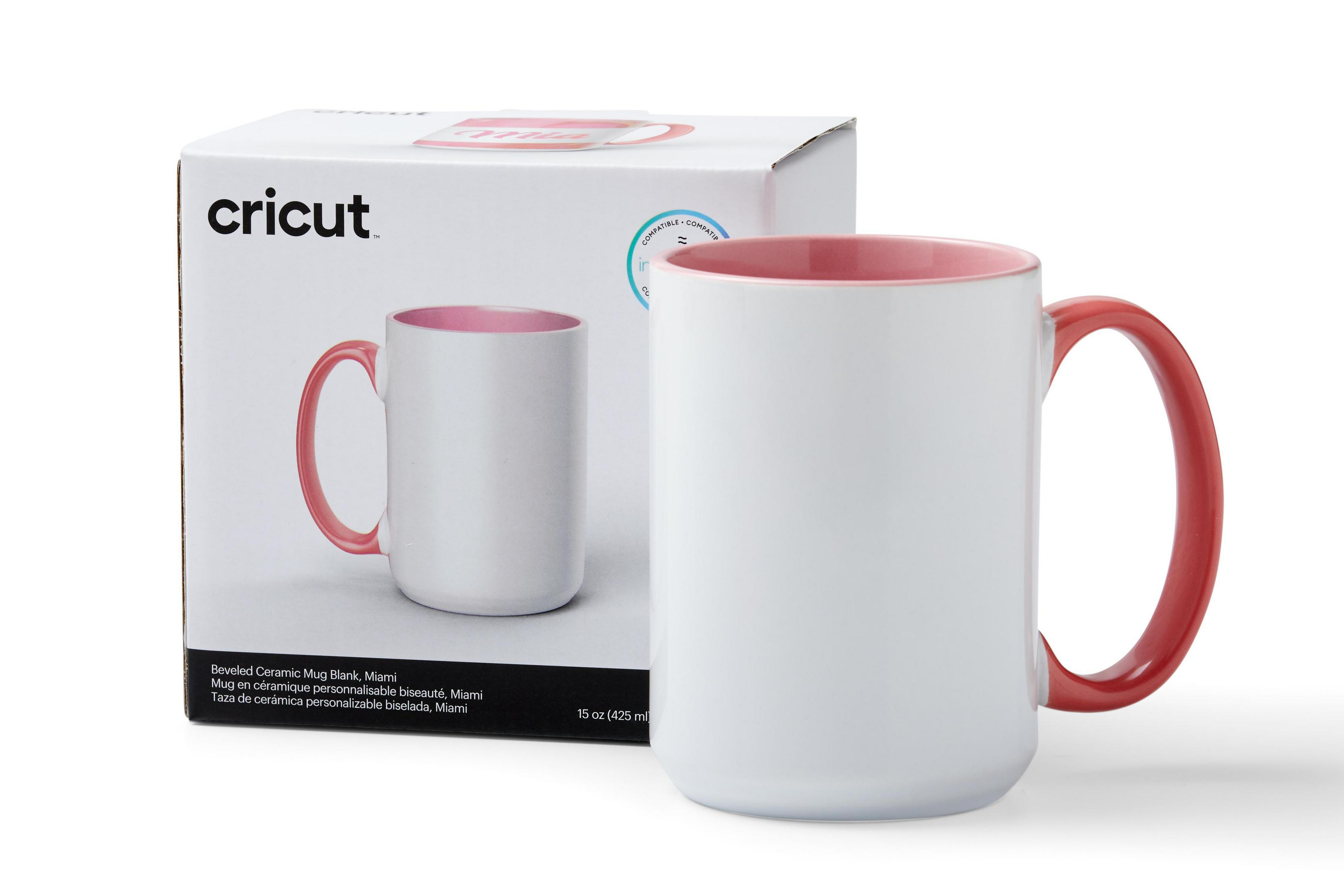 Eine weiße Tasse mit pinkfarbenem Griff und Innenraum, neben ihrer Box.