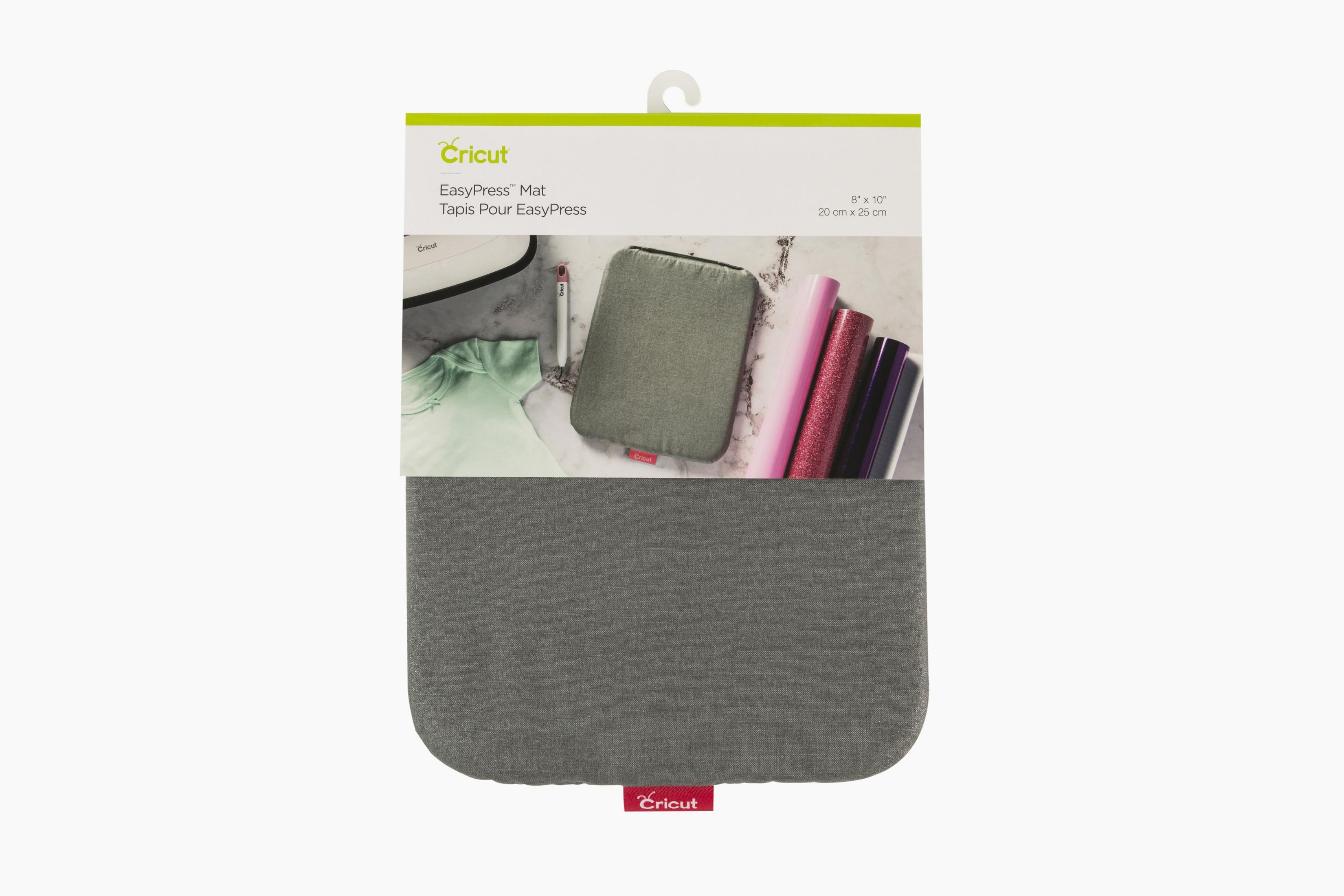 Eine Cricut EasyPress-Matte in einer Verpackung mit einer grauen Matte und einigen Rollen Glitzervinyl.