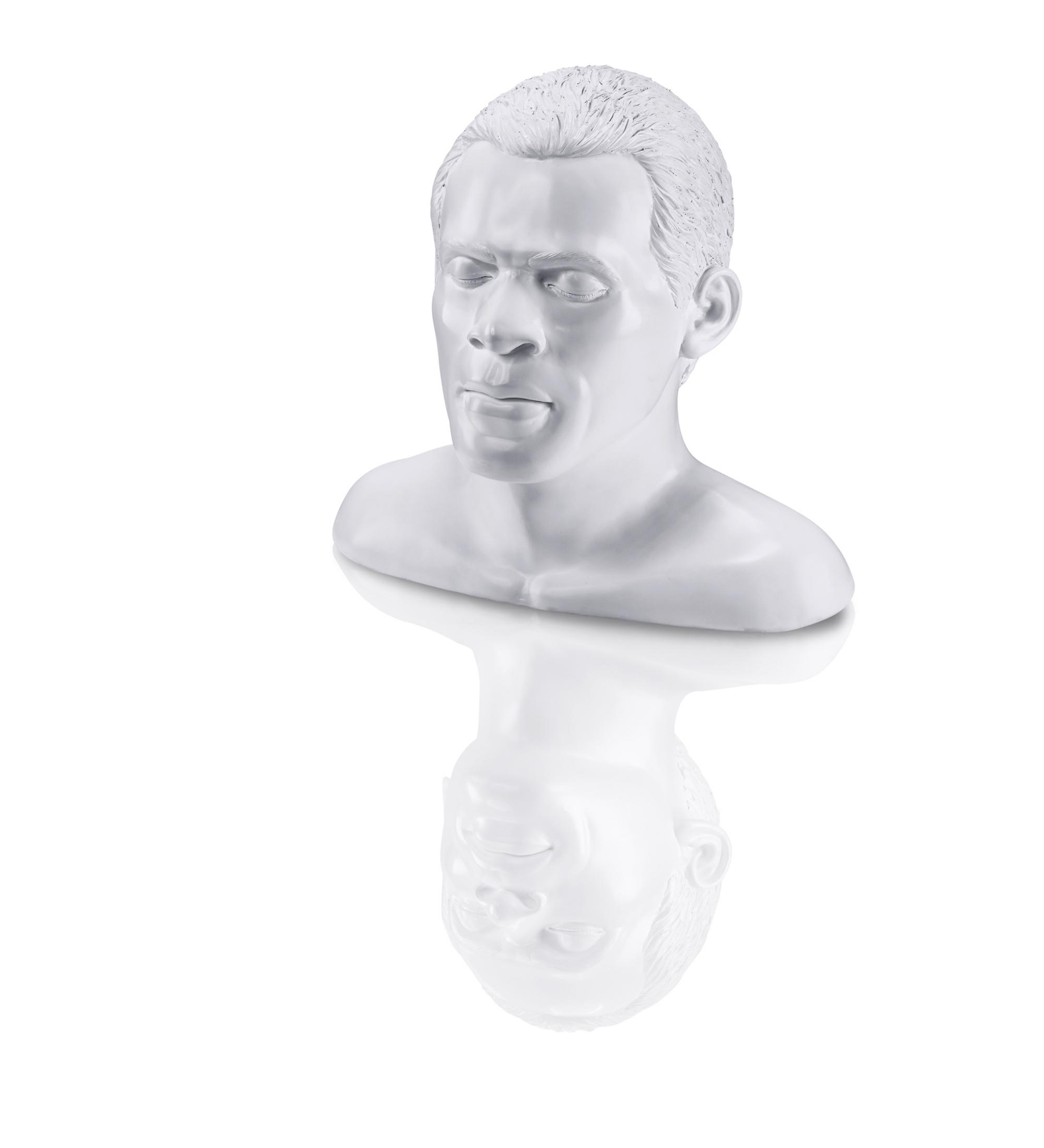 Weiße Skulptur eines männlichen Kopfes. Der Kopf spiegelt sich auf der weißen Oberfläche.