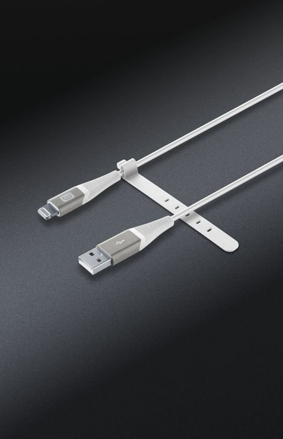 Weißes und graues Ladekabel für ein Telefon, gehalten von einem weißen Riemen auf schwarzem Grund.