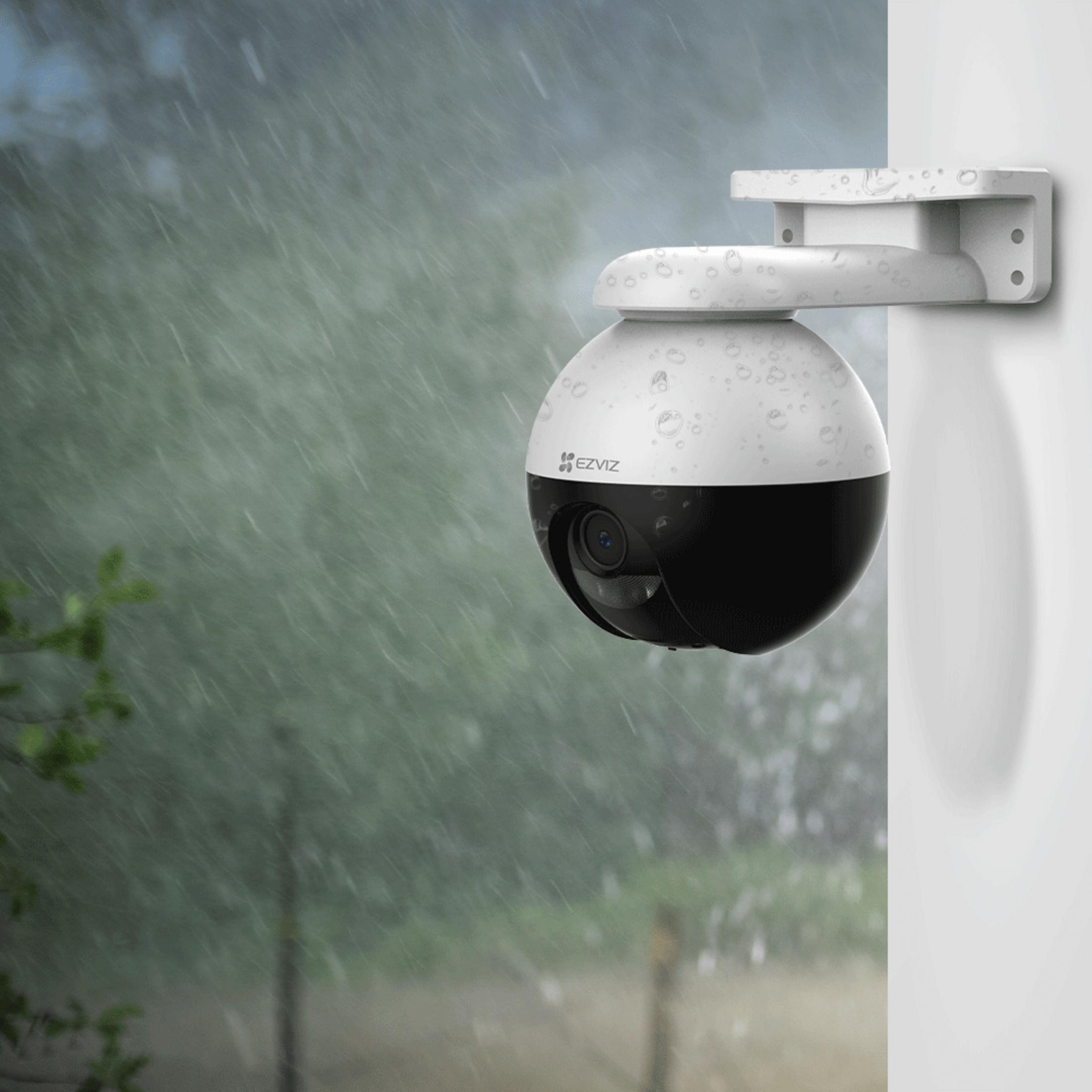 Czarno-biała kamera bezpieczeństwa w deszczu, zamontowana na ścianie.