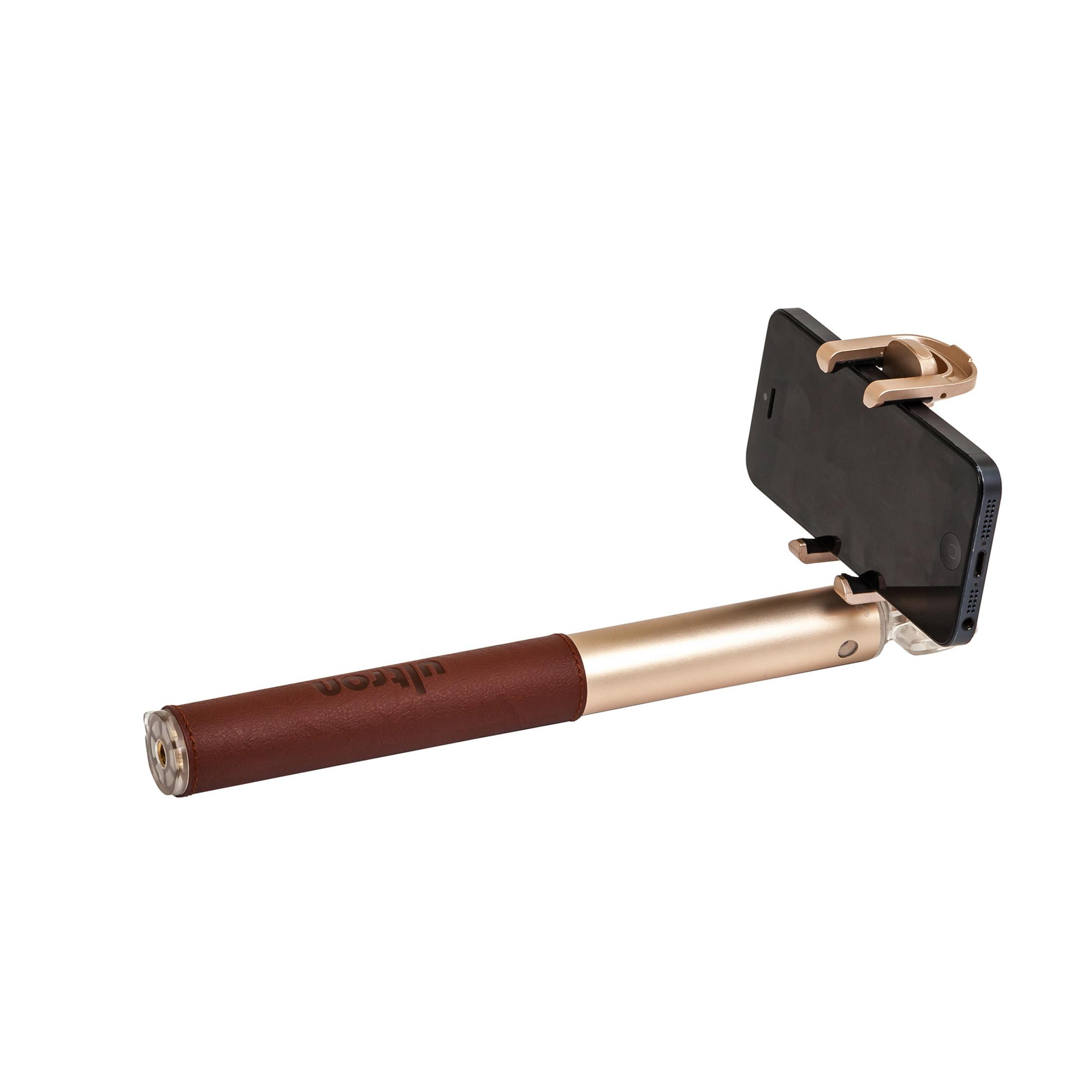Selfie-Stick mit befestigtem Telefon. Es hat einen braunen Griff und einen goldenen Halter. Weißer Hintergrund.